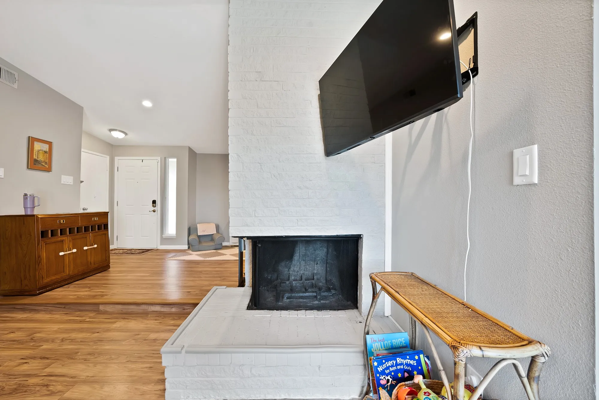 Living room featuring light wood-style floors, a multi sided fireplace, and recessed lighting