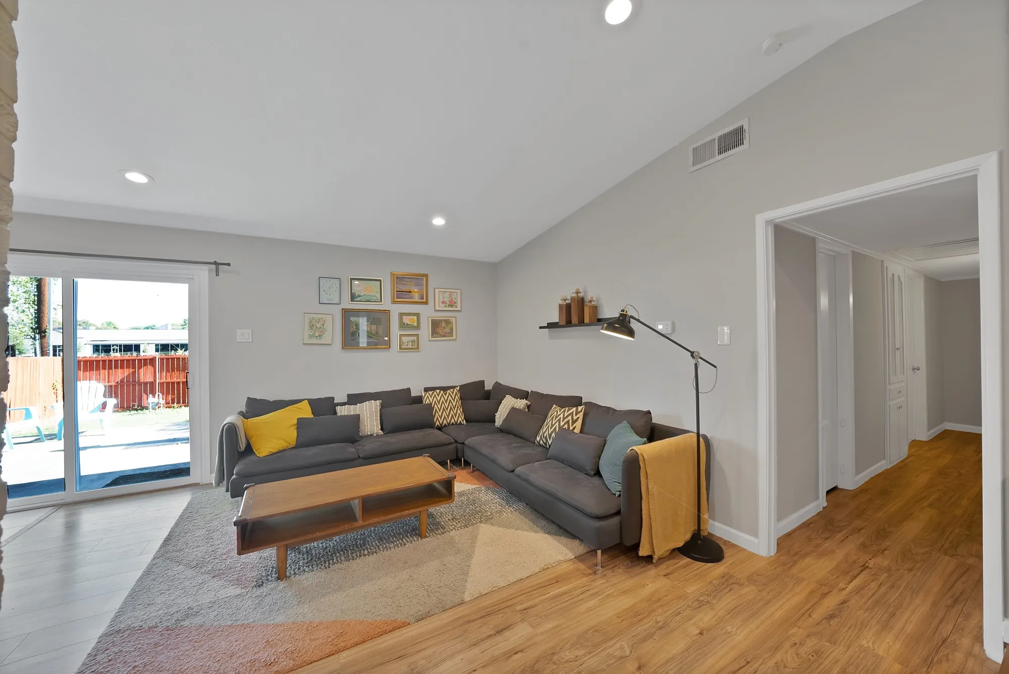 Living room with vaulted ceiling, recessed lighting, and light wood-type flooring