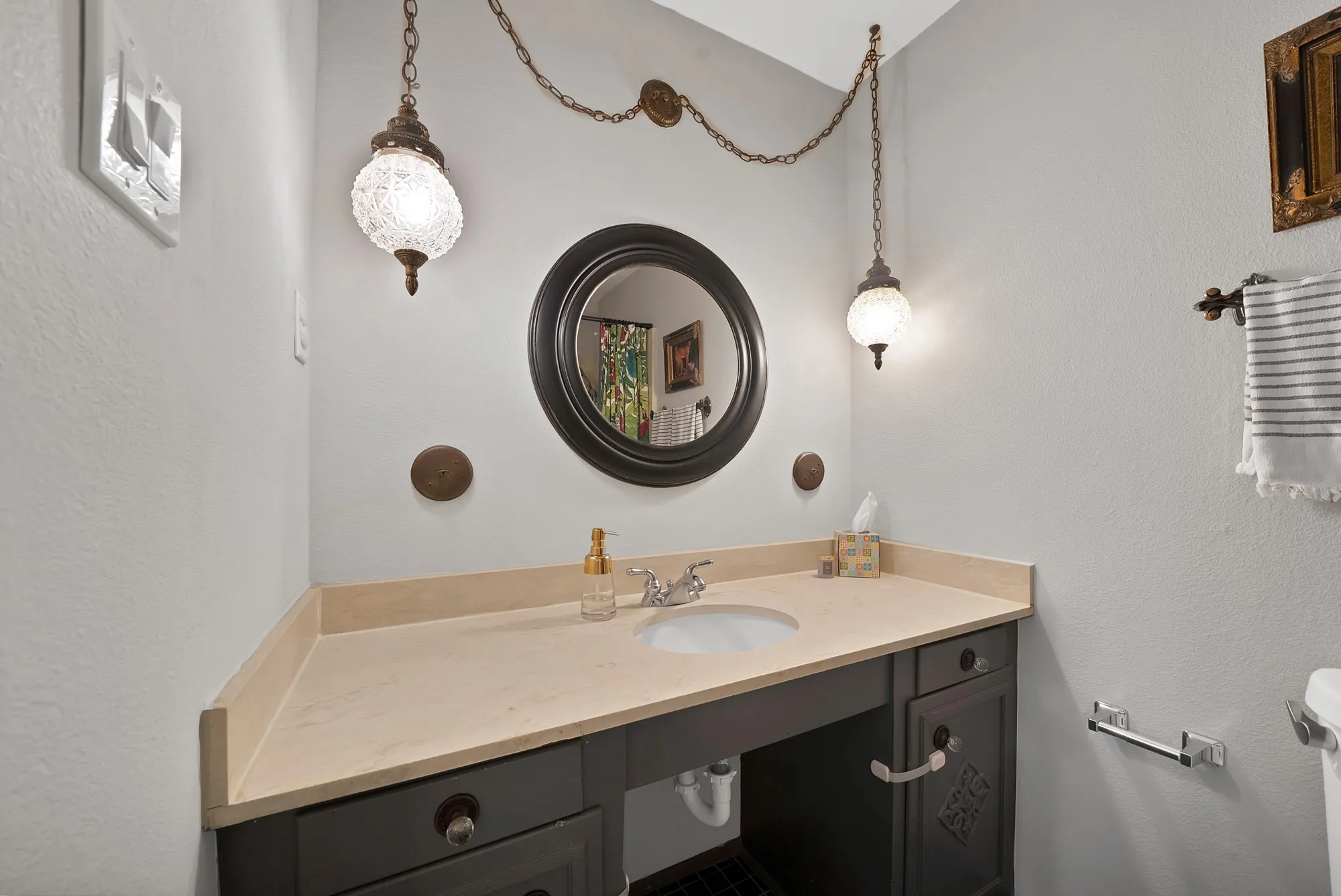 Bathroom featuring a textured wall and vanity