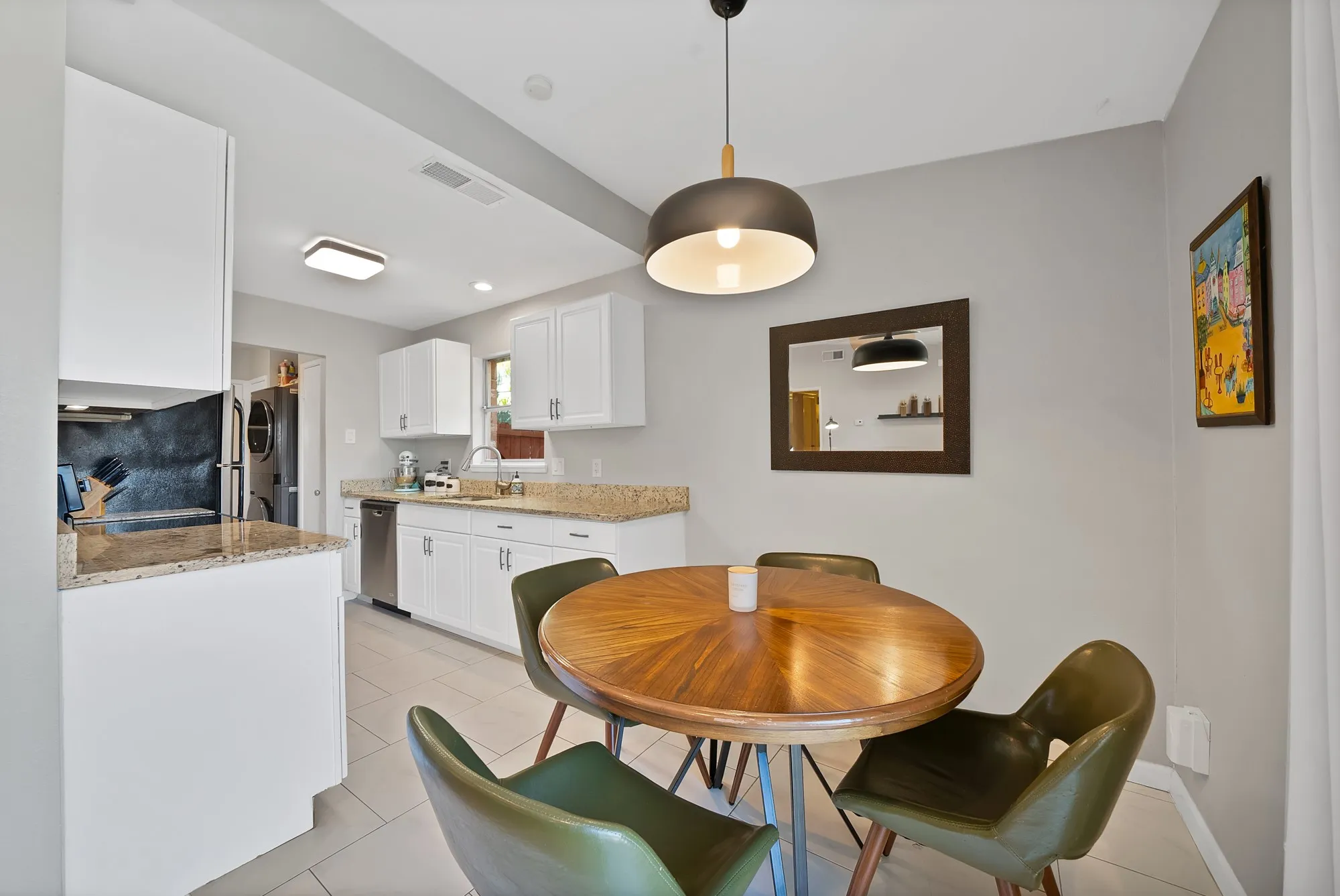 Dining room with light tile patterned flooring and estacked washer and dryer