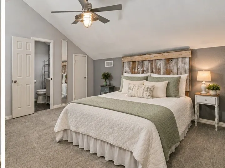 Angled ceiling, recessed lighting, ceiling fan with integrated light, wood-finish accent wall, and soft carpeting