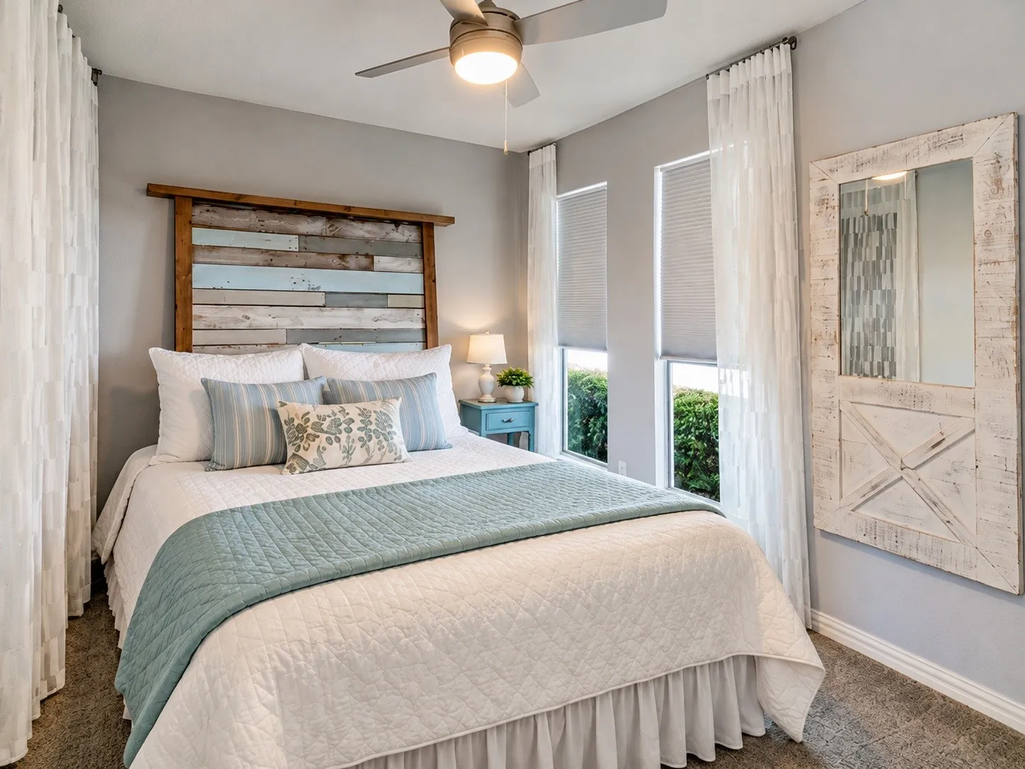 Ceiling fan with integrated lighting, dual windows with blinds and sheer curtains, wood-paneled accent wall, and plush carpet flooring