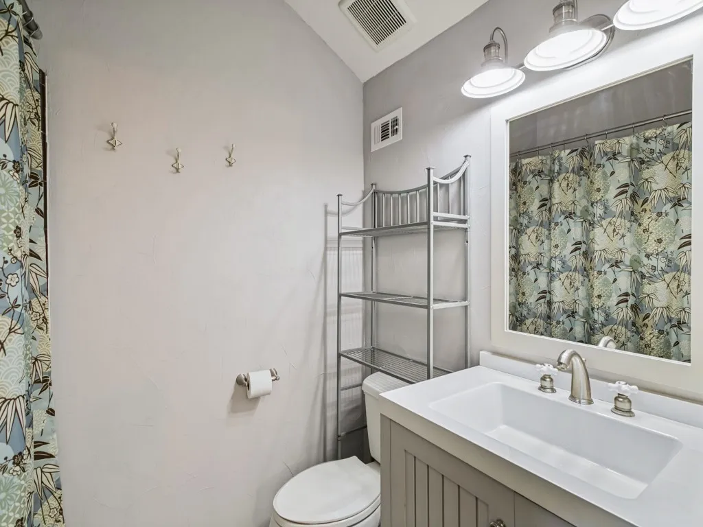 Vanity with an integrated sink, brushed nickel faucet, and beadboard paneling