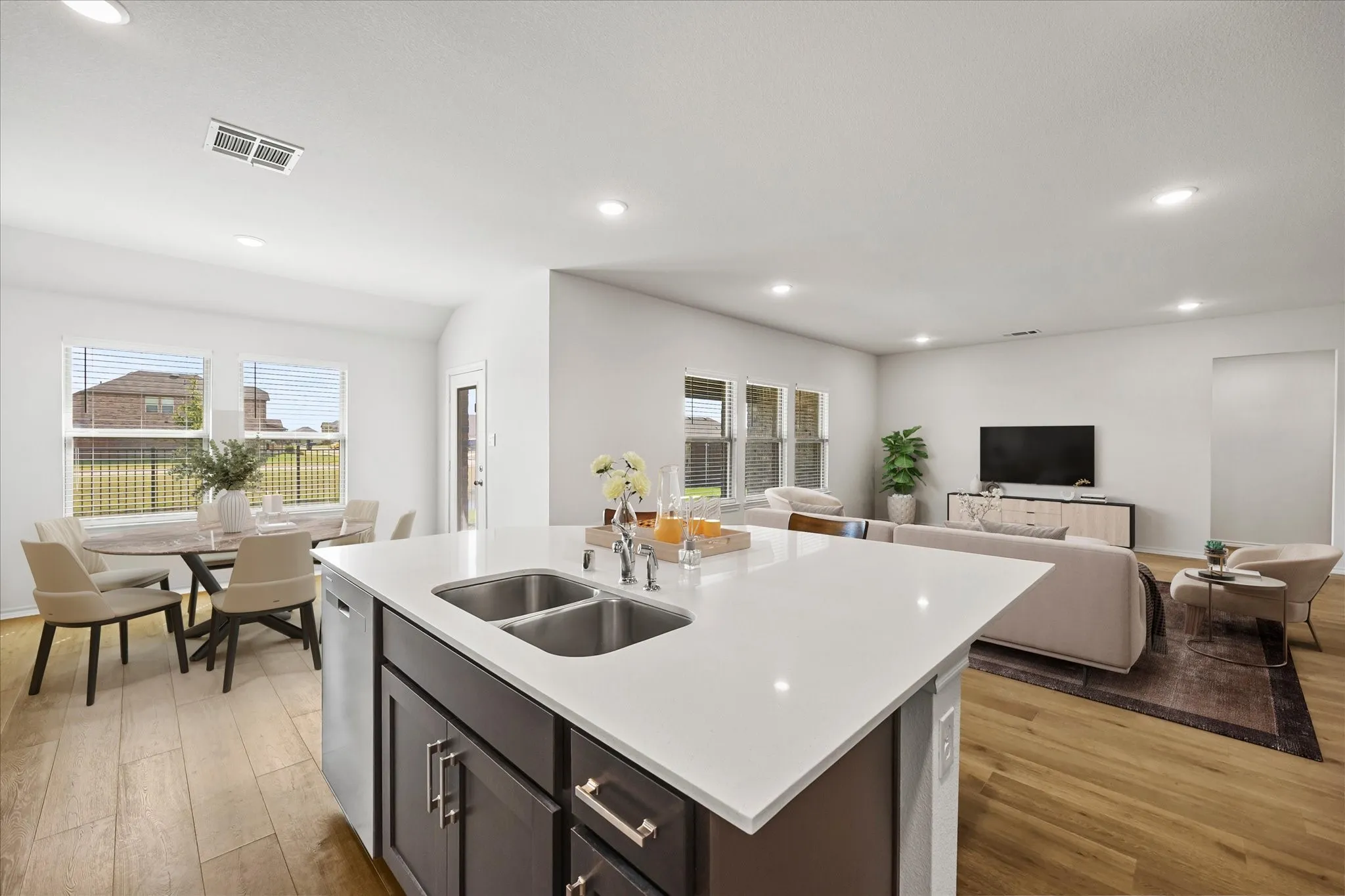 Kitchen with center island opens onto dining area and family room. Virtually staged.