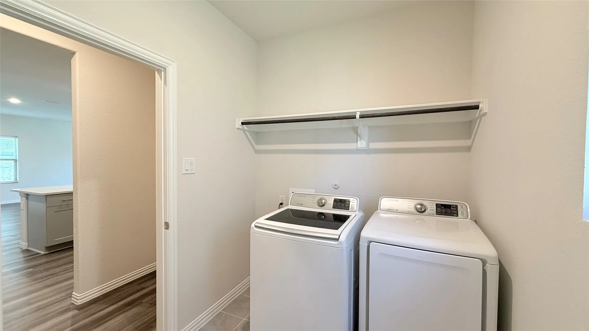 Dedicated utility space featuring a built-in shelving unit and rod