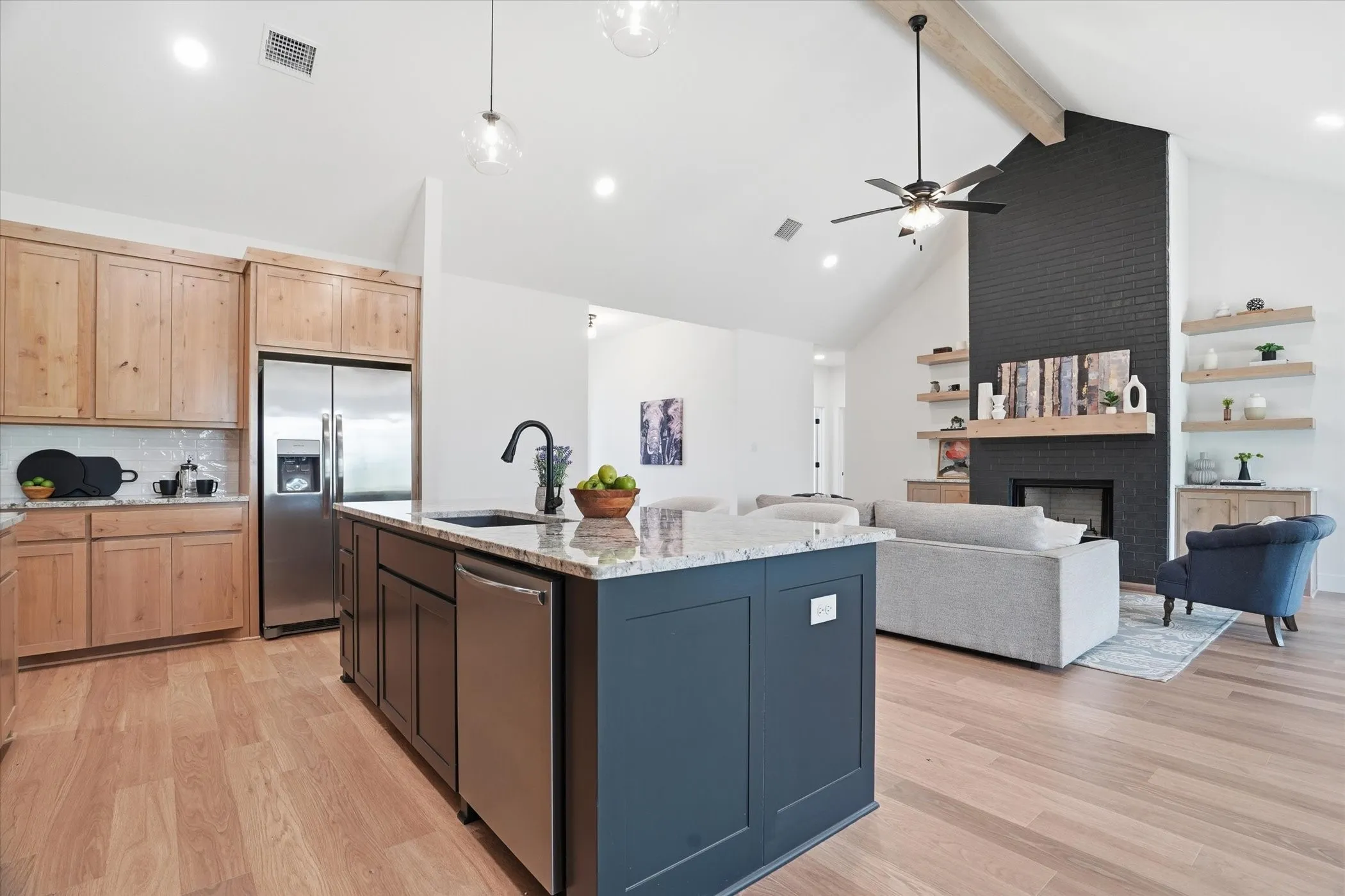 Kitchen island with granite countertop, integrated sink, and stainless steel dishwasher