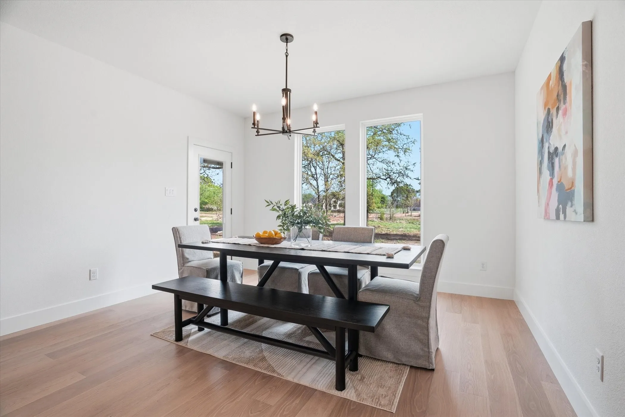 Light wood-finish flooring with white baseboards