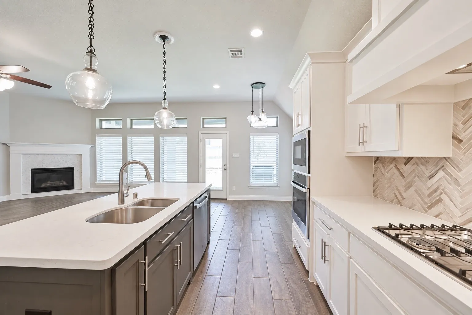 Kitchen island featuring a double-basin sink and pendant lighting