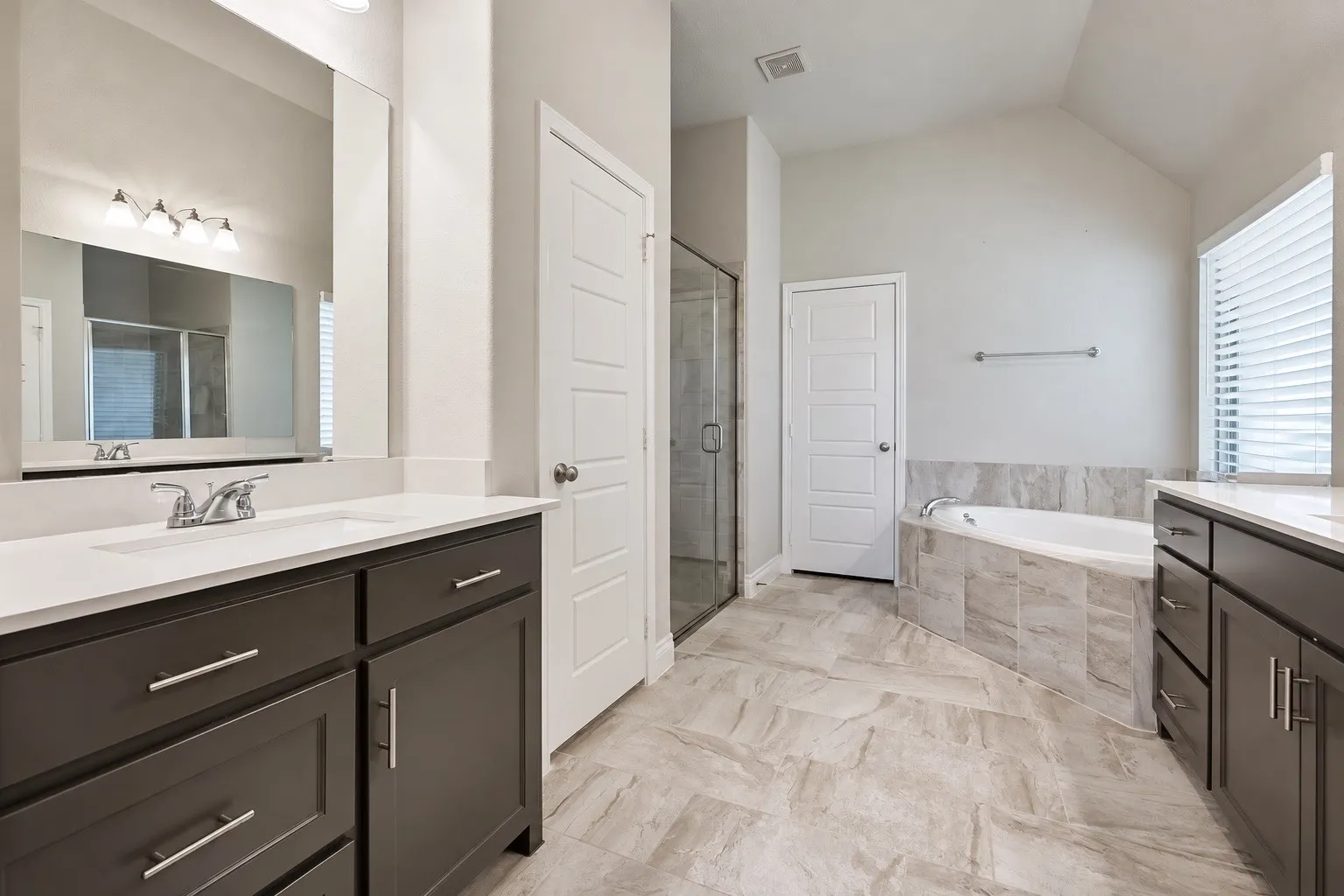 Dual vanity with undermount sinks, white countertops, and dark wood-finish cabinetry