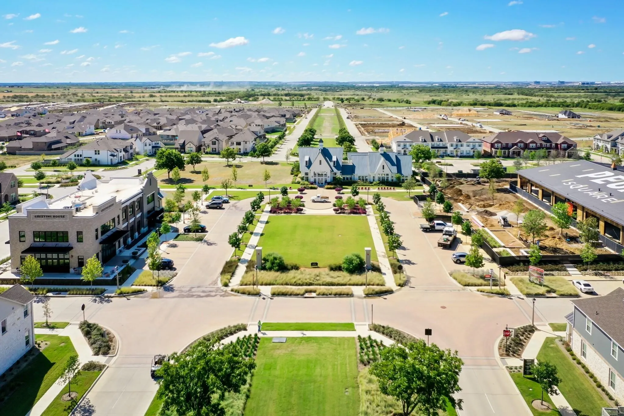 Expansive community with a central greenspace, surrounded by residential properties and commercial structures