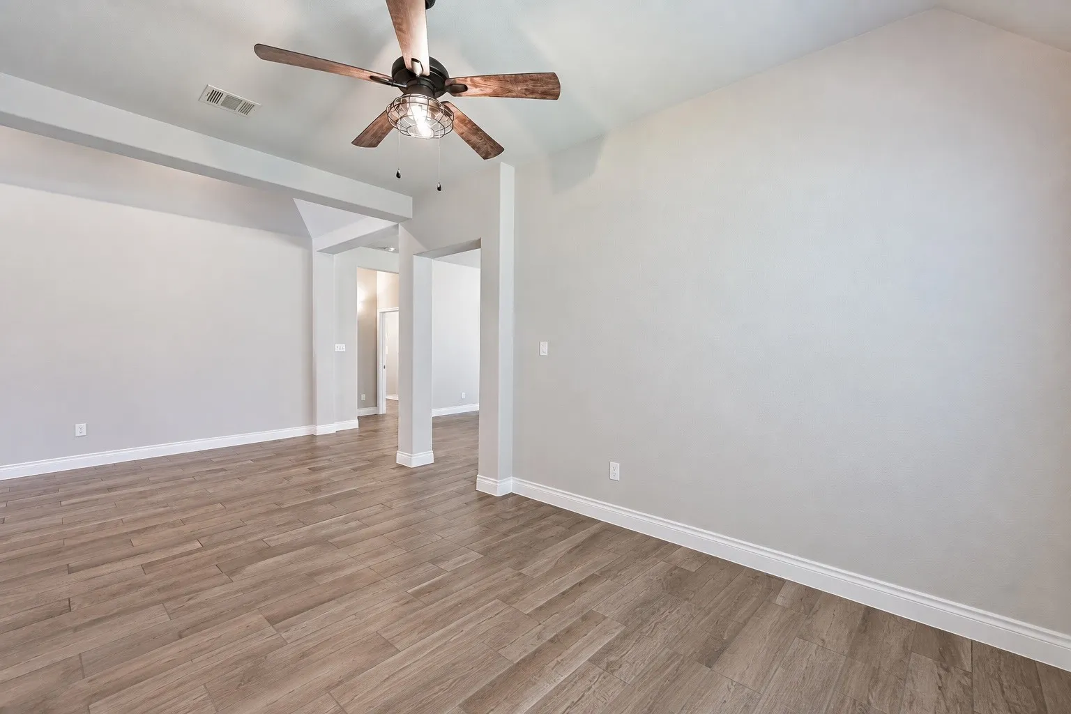 Wood-finish flooring throughout, complemented by light-toned wall finishes and white trim