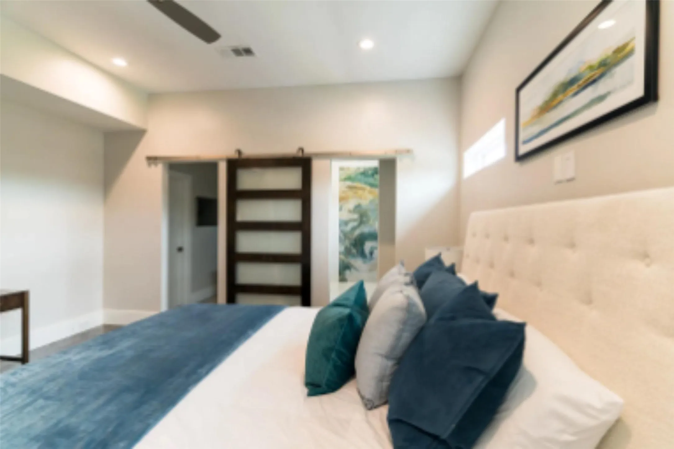 Primary bedroom with view of marble shower behind the sliding door