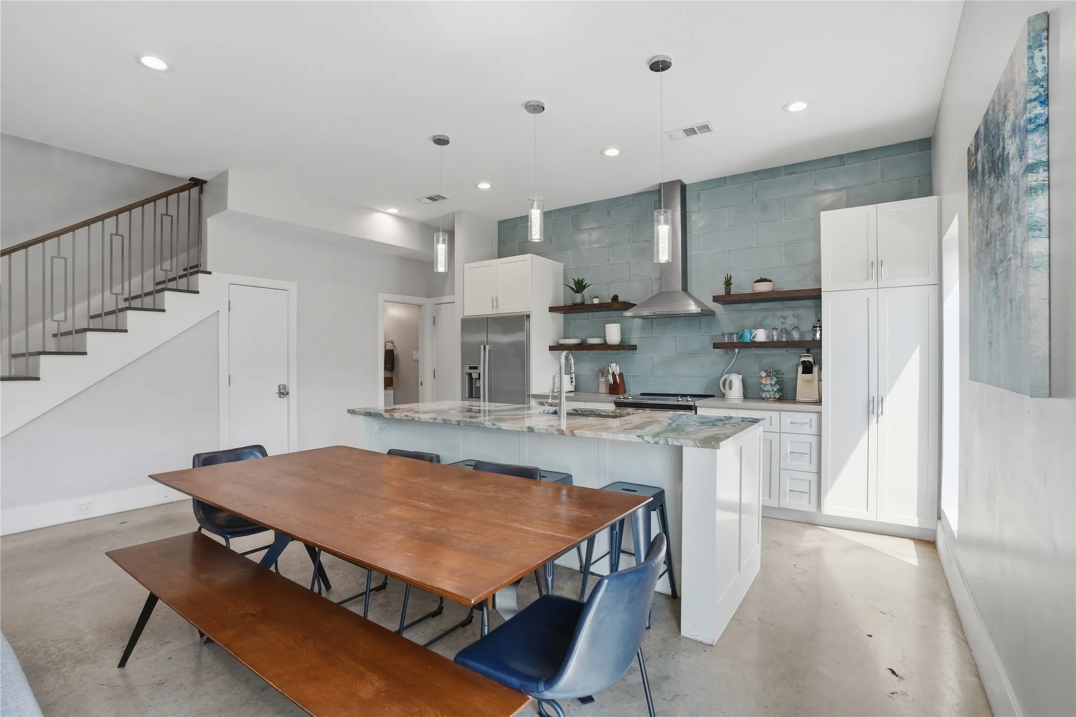 Kitchen features floating shelves, custom countertops and backsplash, and S/S appliances