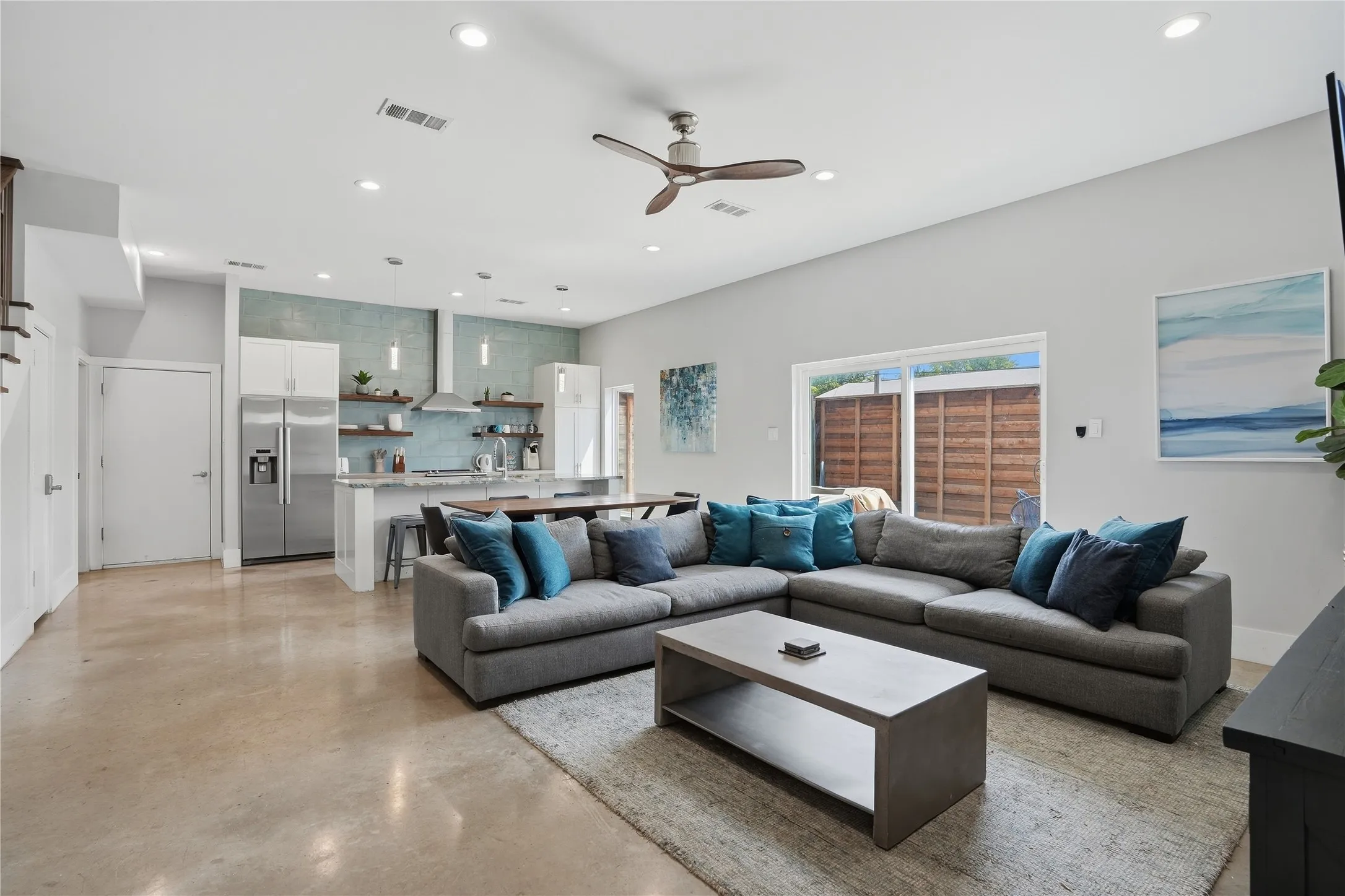 Open living and kitchen areas with concrete flooring