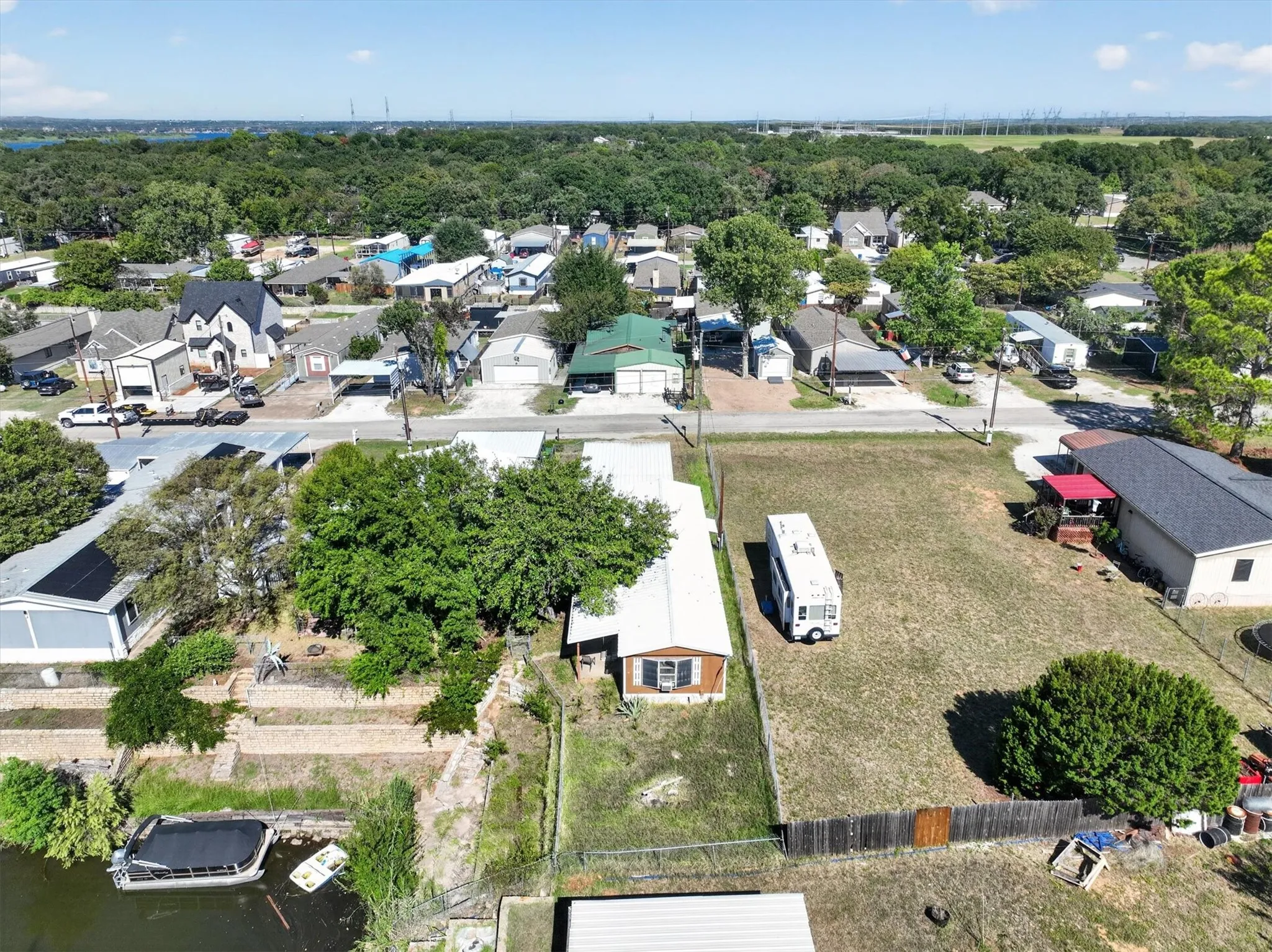 Waterfront property featuring a private boat dock, mature trees, and a spacious yard