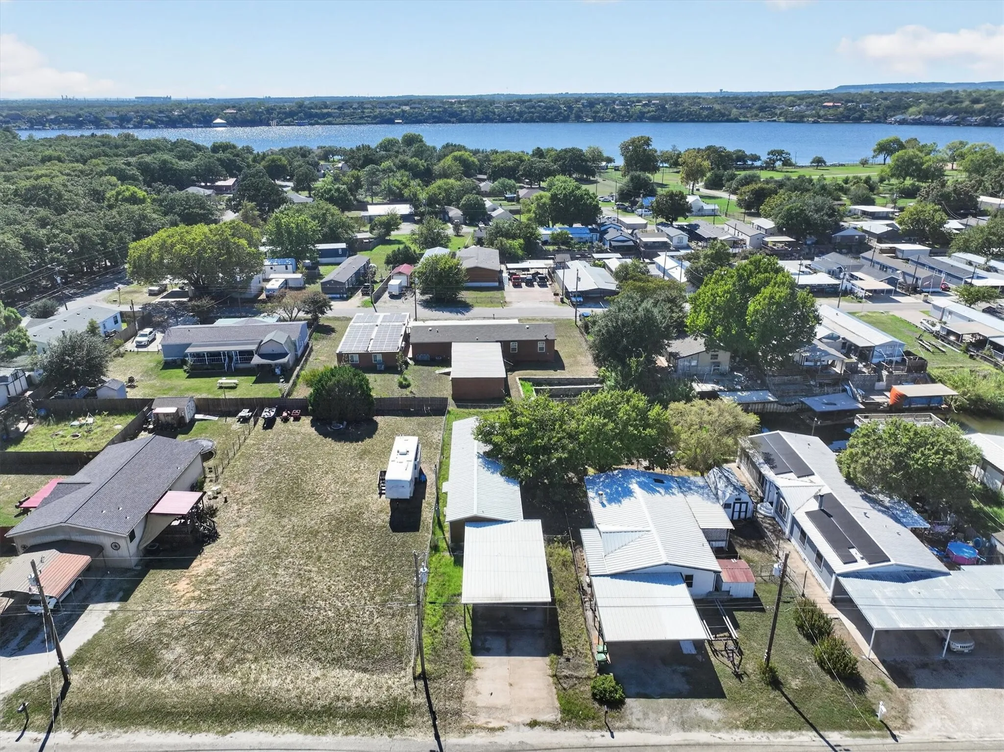 Expansive body of water, distant tree lines, and a residential area with various roof types