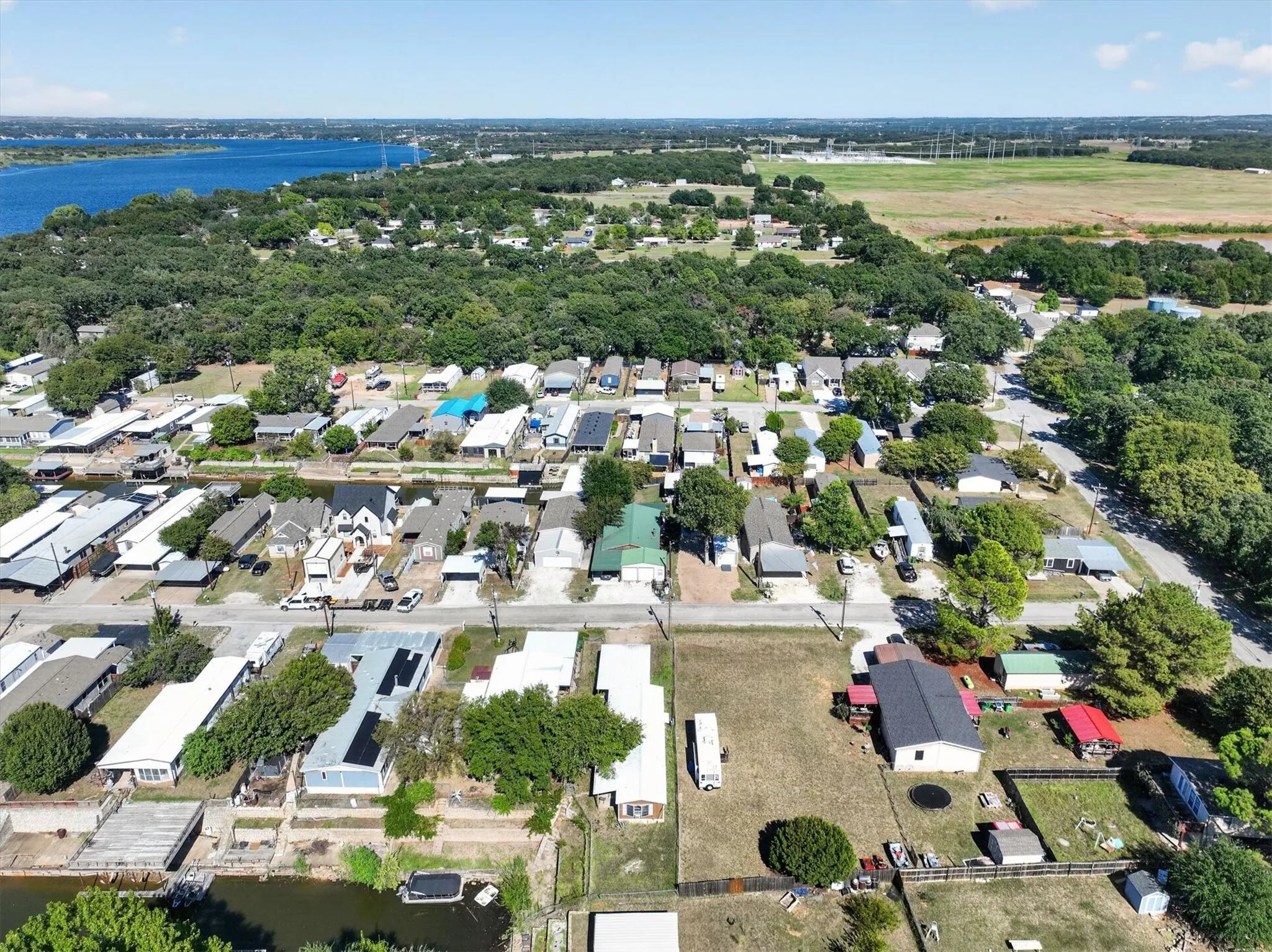 Expansive water body, residential properties, treed areas, and open fields within the surrounding landscape