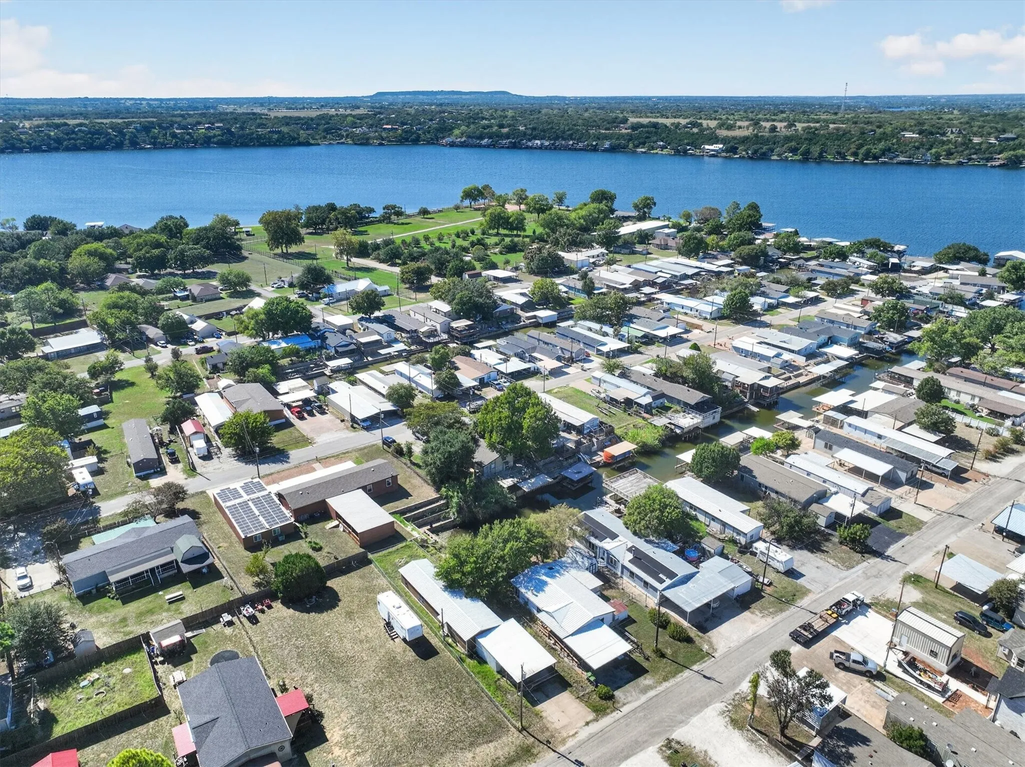 Aerial perspective showcasing diverse residential properties and a prominent natural water body