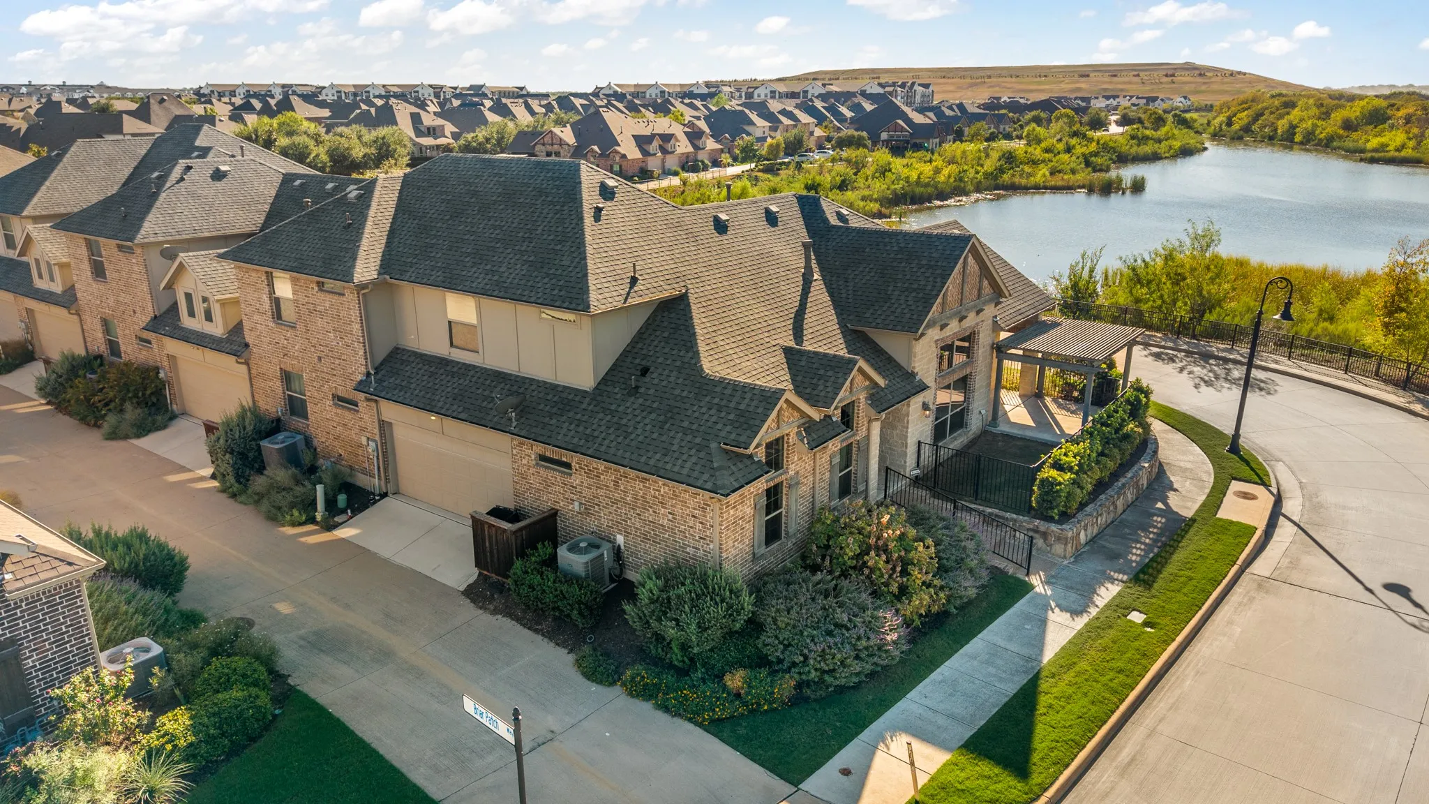 Brick and stone exterior with a dark shingle roof