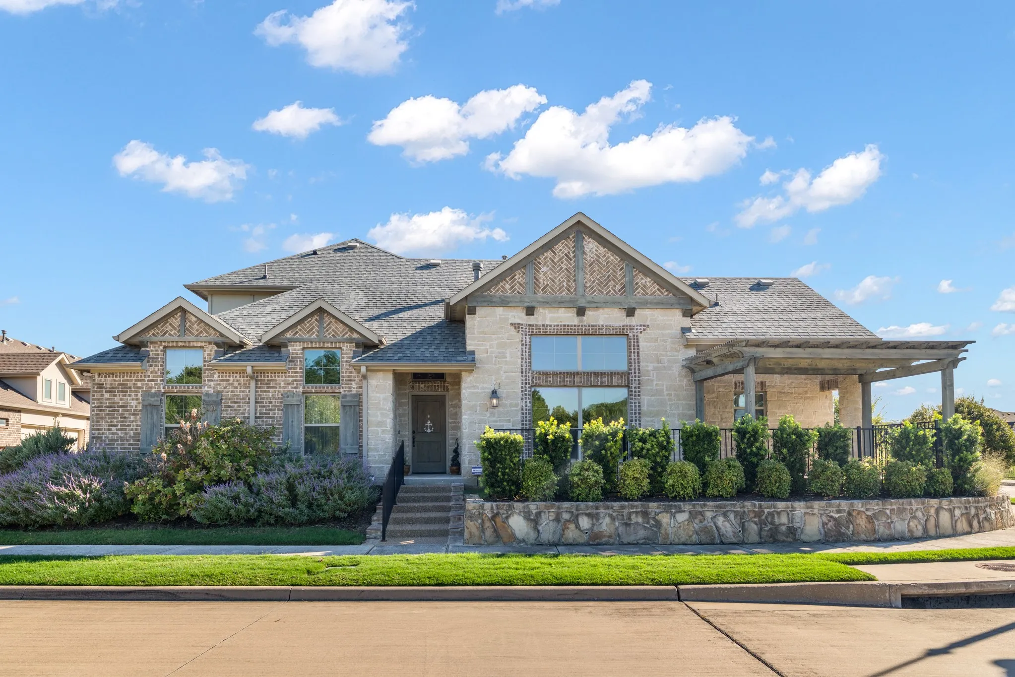 Elegant stone and brick exterior with gabled rooflines and multiple arched windows