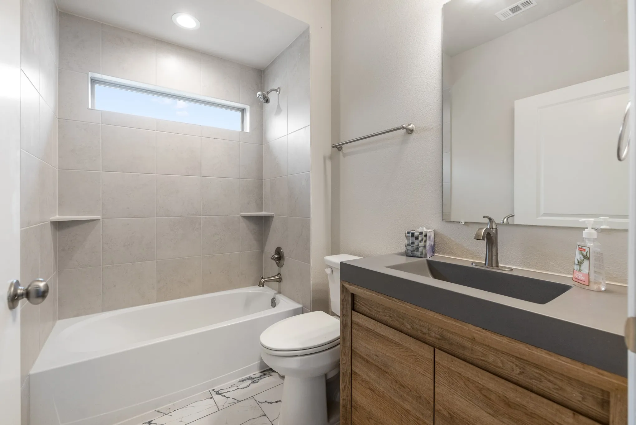 Modern vanity with wood-finish cabinetry and integrated sink