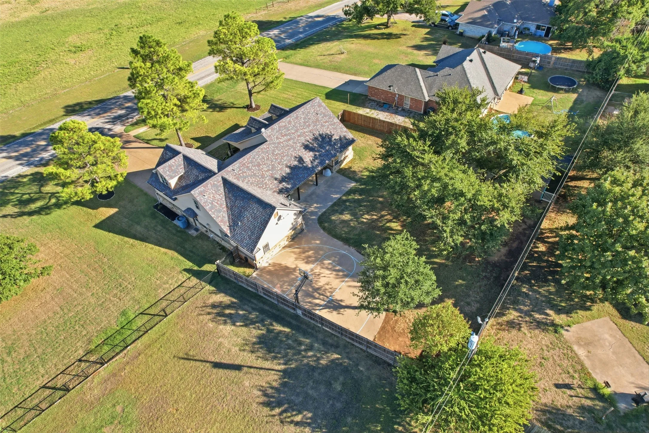 Expansive property with a multi-gabled roofline, stone and siding exterior, concrete driveway, and mature landscaping