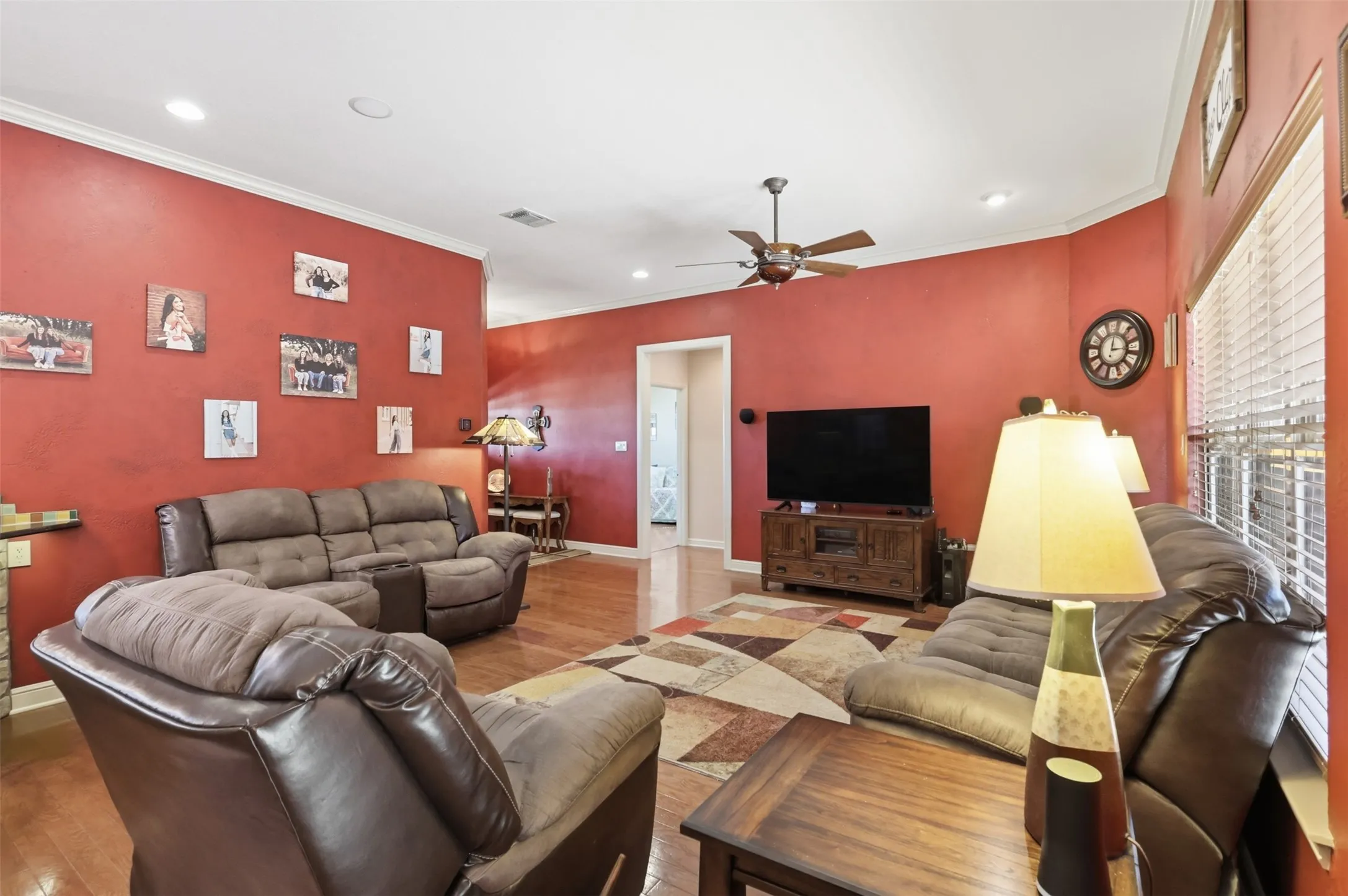 Living area with wood-finish flooring, recessed lighting, crown molding, and a ceiling fan