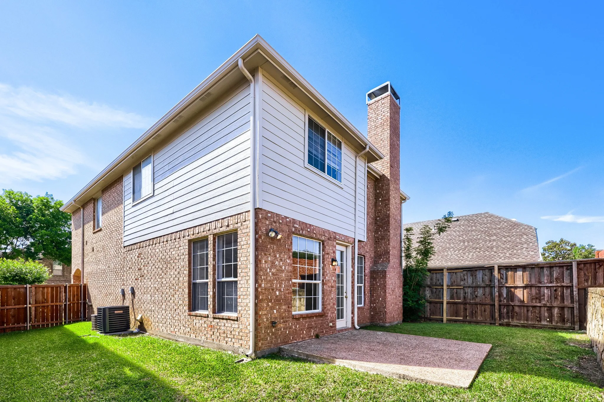 Brick exterior with white siding accents and a prominent brick chimney