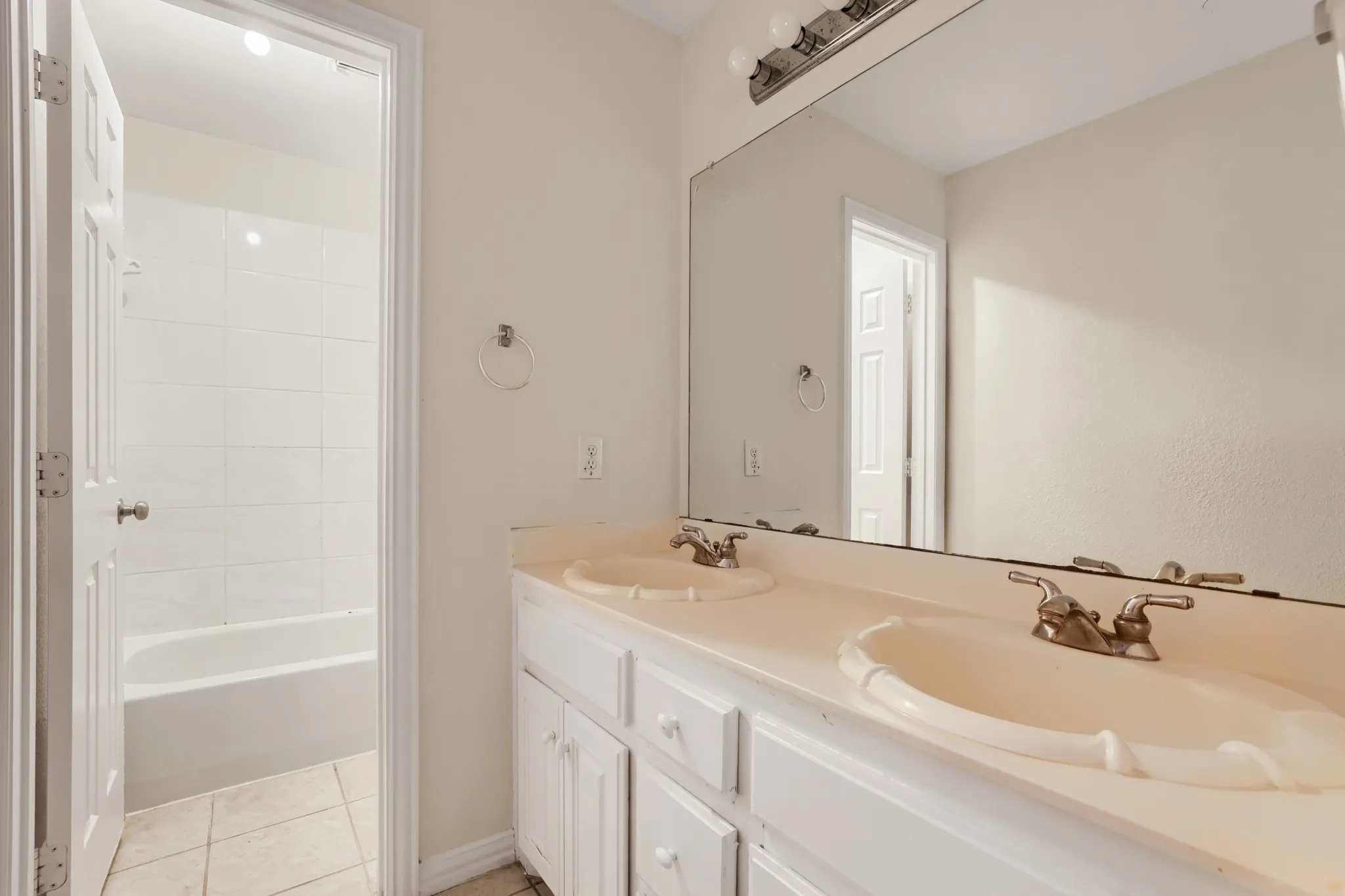 Dual vanity with integrated sinks, brushed nickel fixtures, and white cabinetry