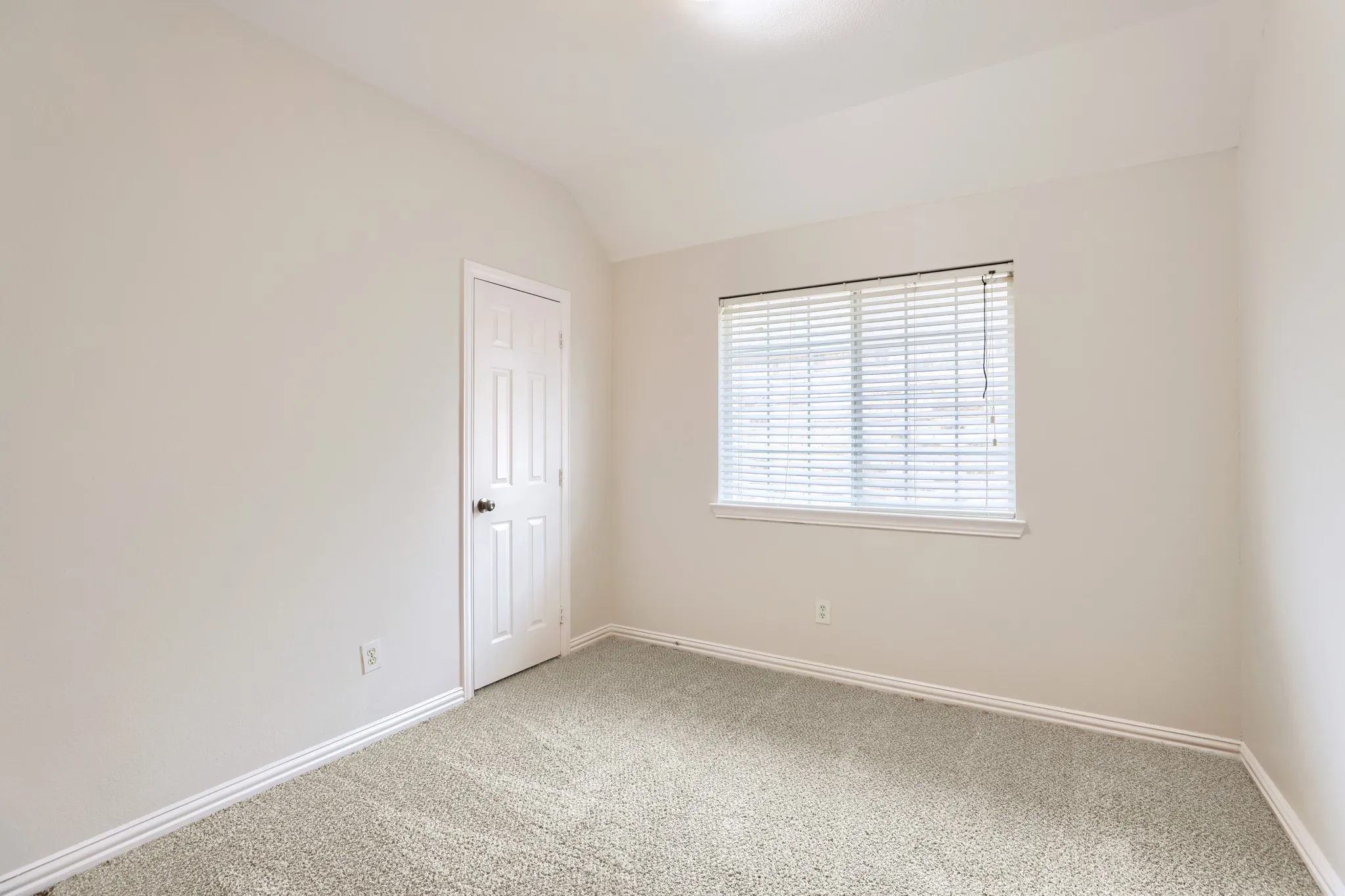 Light-colored carpet, neutral wall paint, single window with blinds, paneled interior door, and recessed lighting