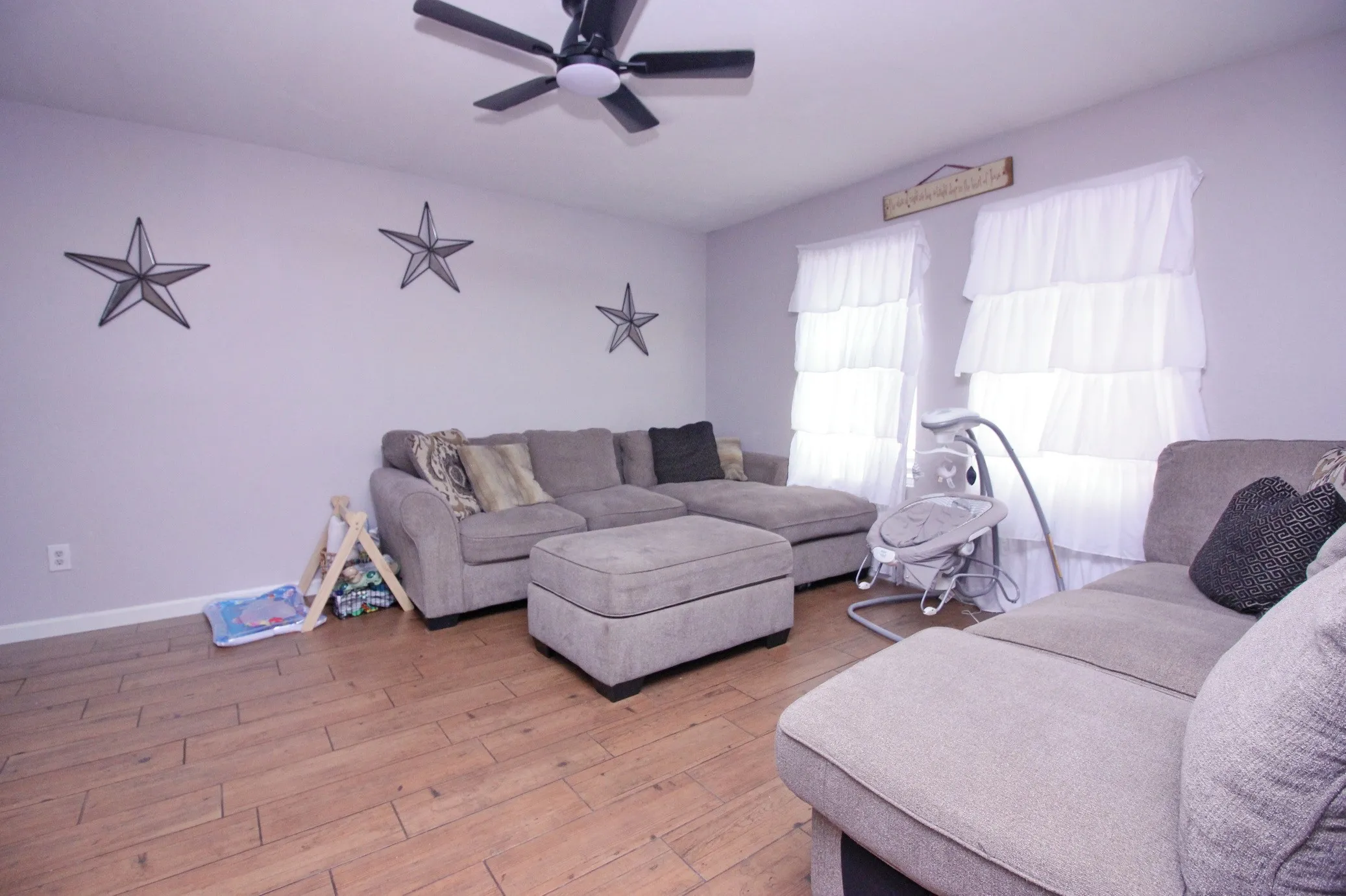 Wood-finish flooring, ceiling fan with integrated lighting, and light-toned wall paint