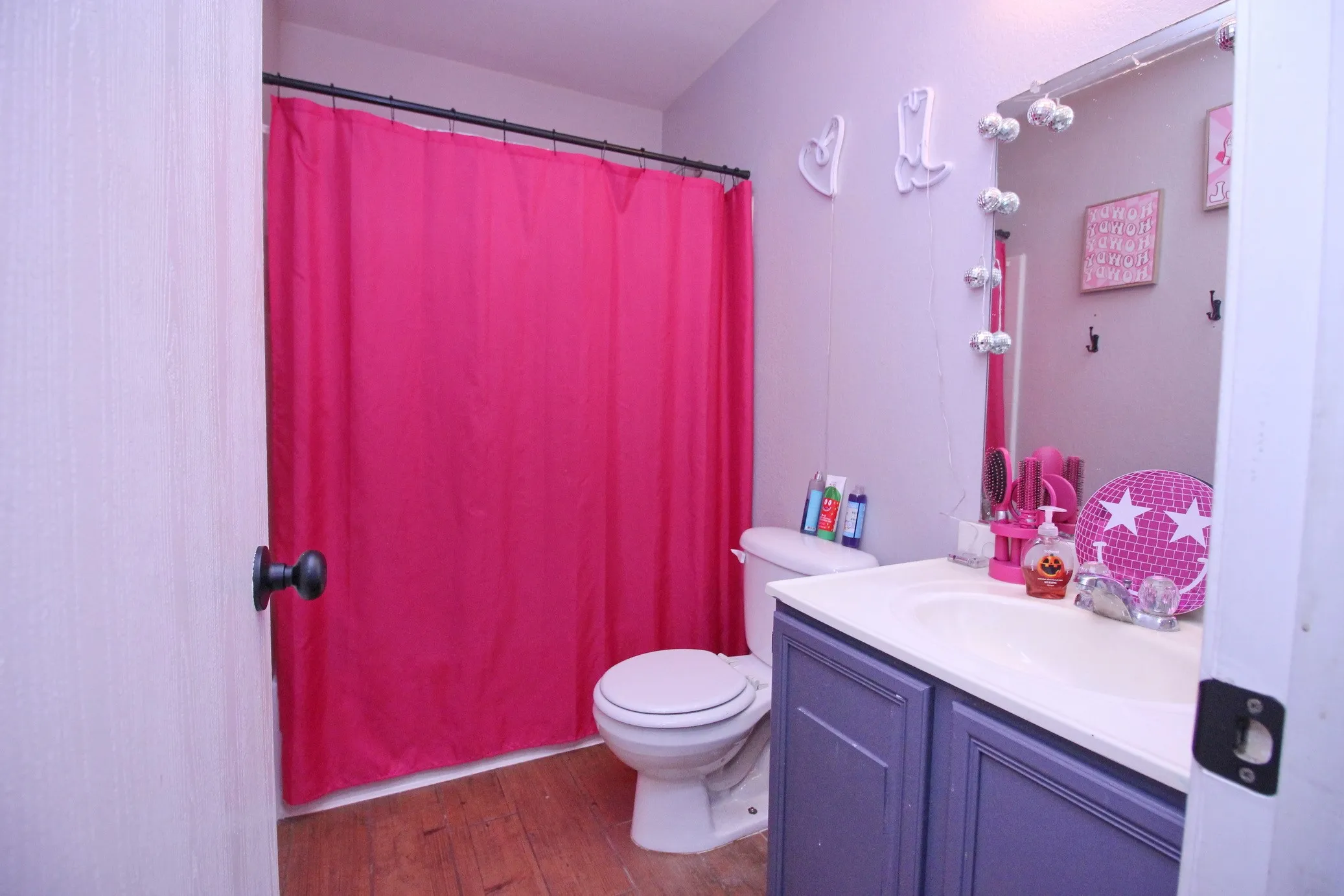 Vanity with white countertop, integrated sink, and purple wood-panel cabinet doors