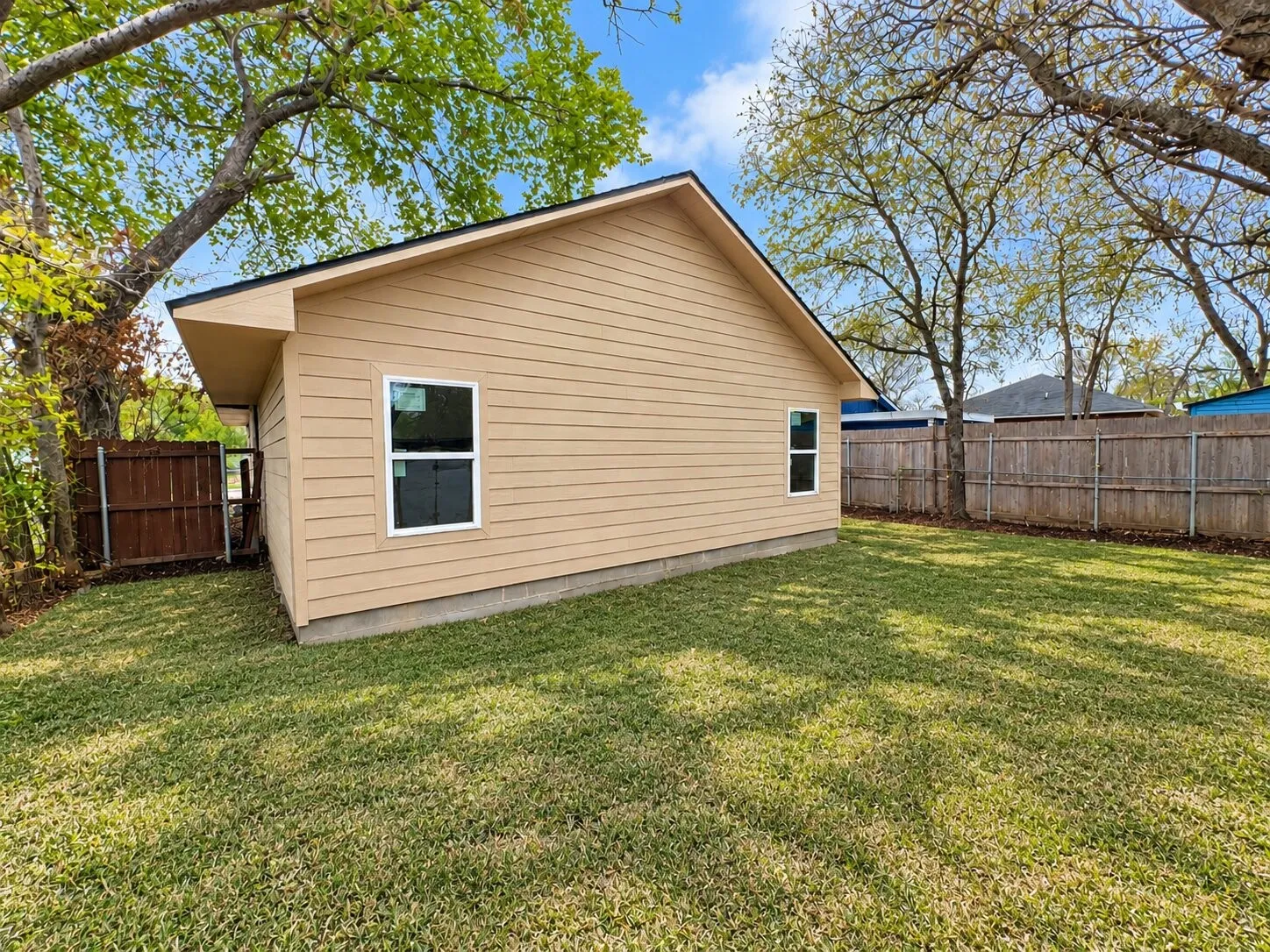 Exterior siding, white-trimmed windows, and a black shingle roof