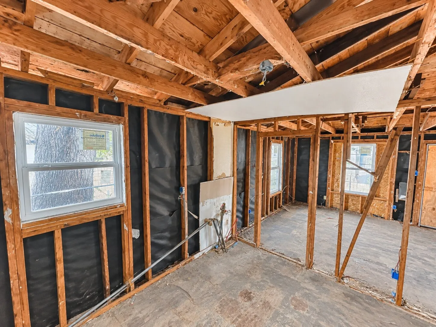 Exposed wood framing, structural ceiling beams, and dual pane windows