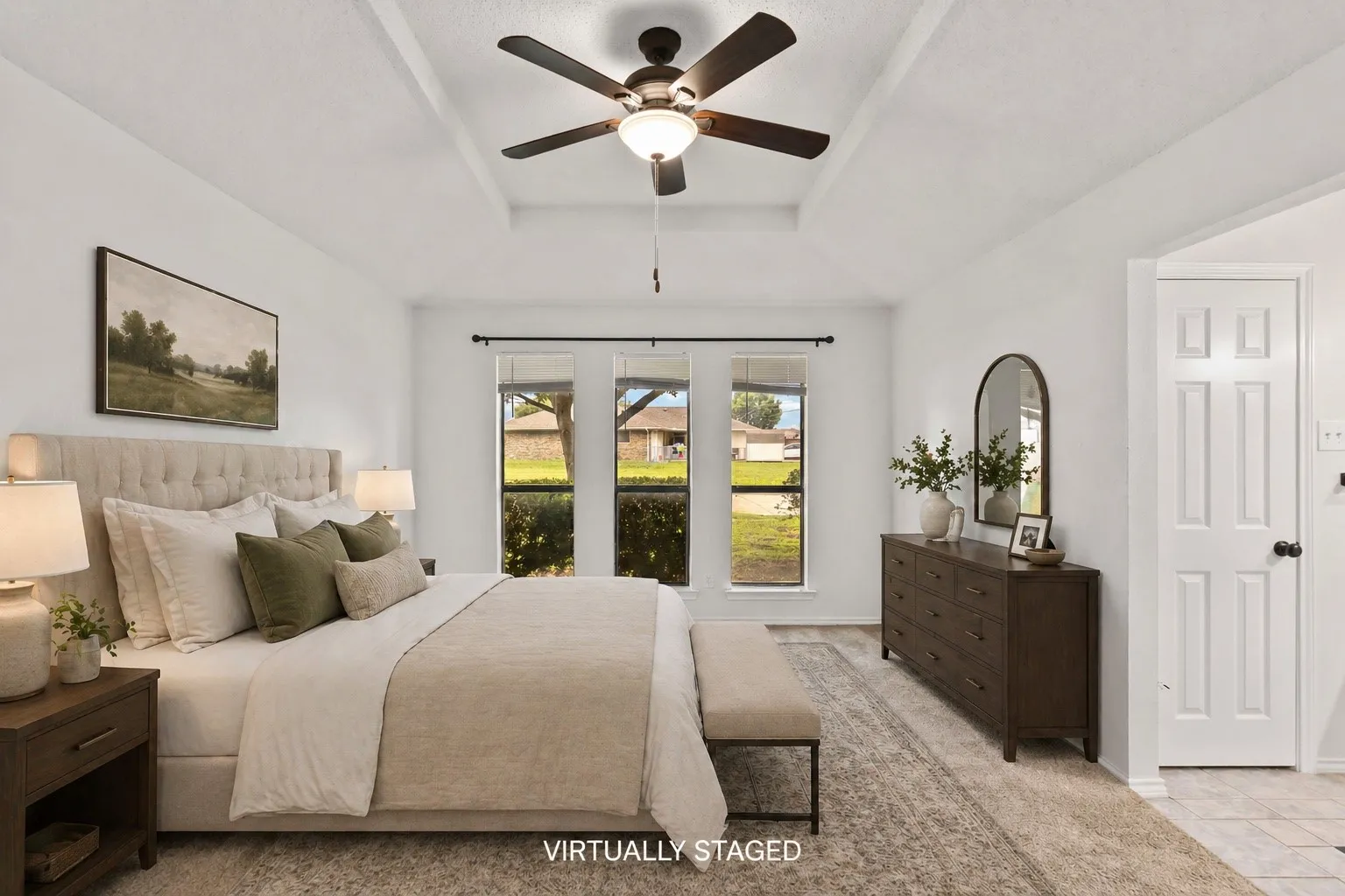 Spacious bedroom with a tray ceiling and a ceiling fan with light fixture
