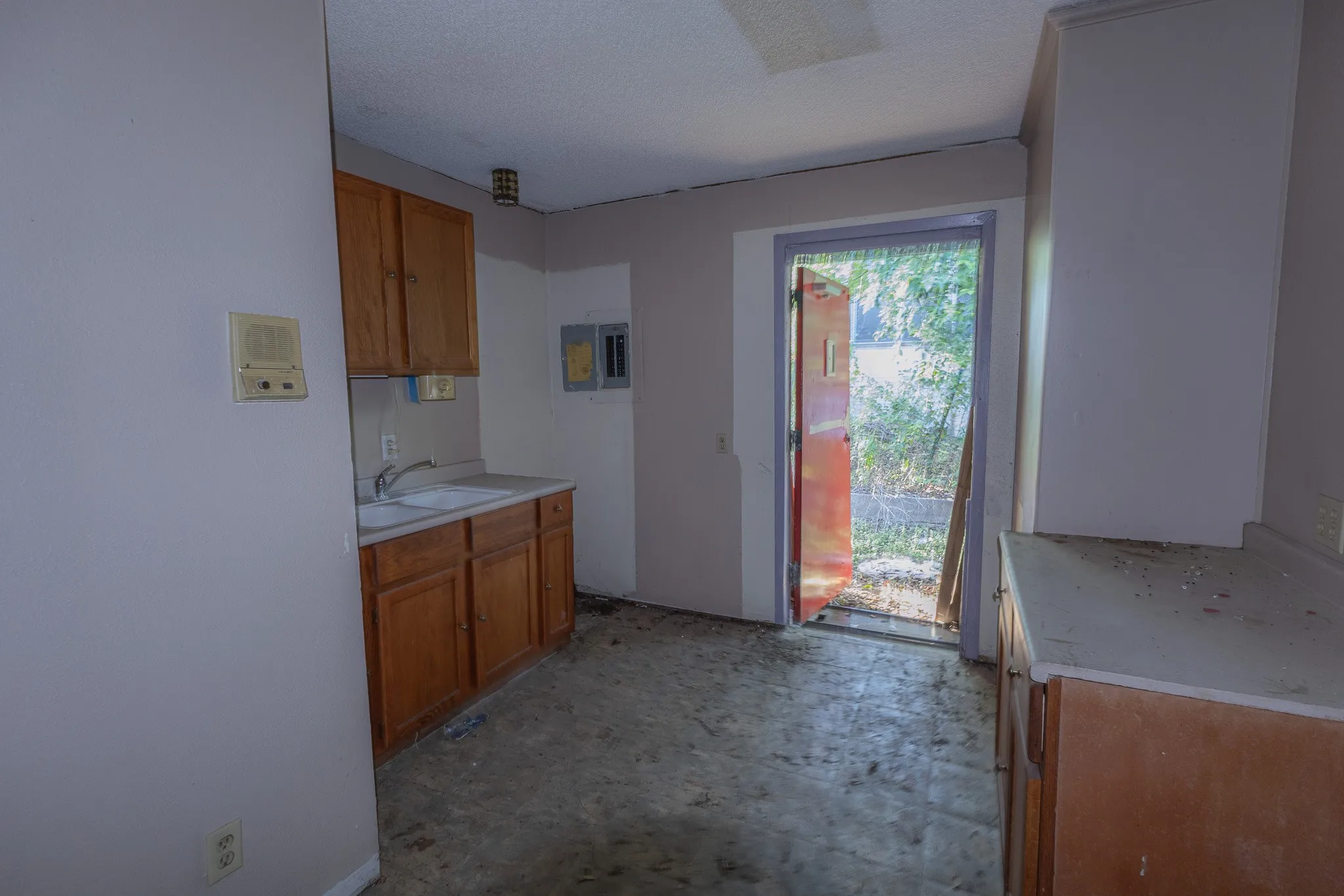 Wood-finish cabinetry, built-in sink, and a rear exterior door