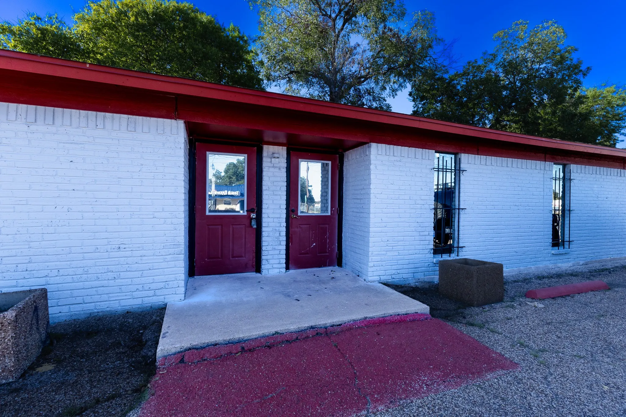 White painted brick exterior with a red roofline