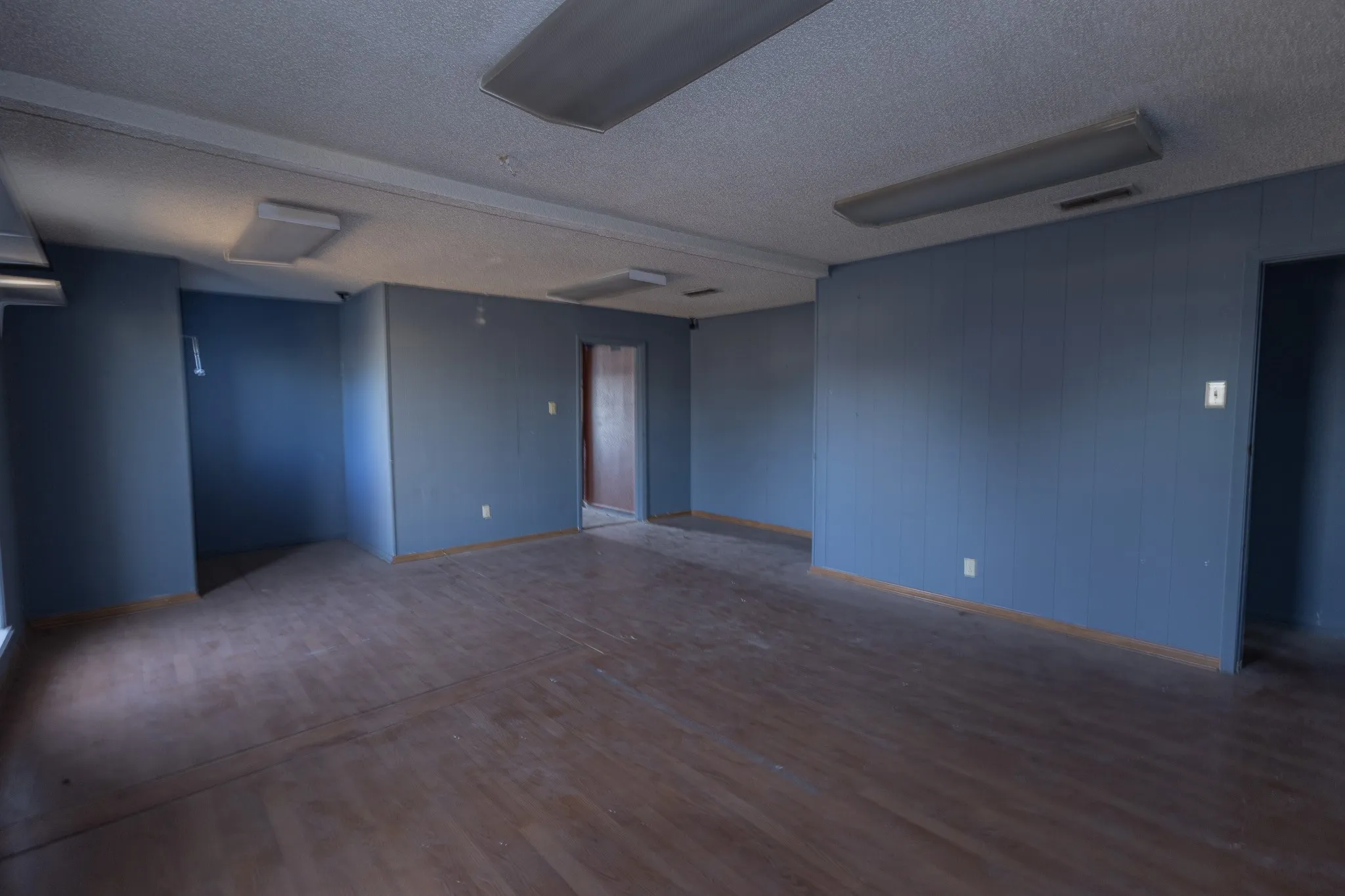 Spacious room featuring wood-finish flooring and a textured ceiling