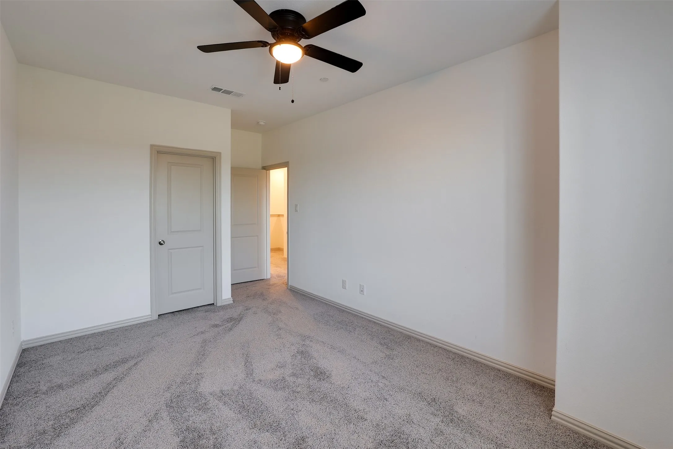 Recessed lighting, ceiling fan, neutral wall paint, gray carpeting, and white trim