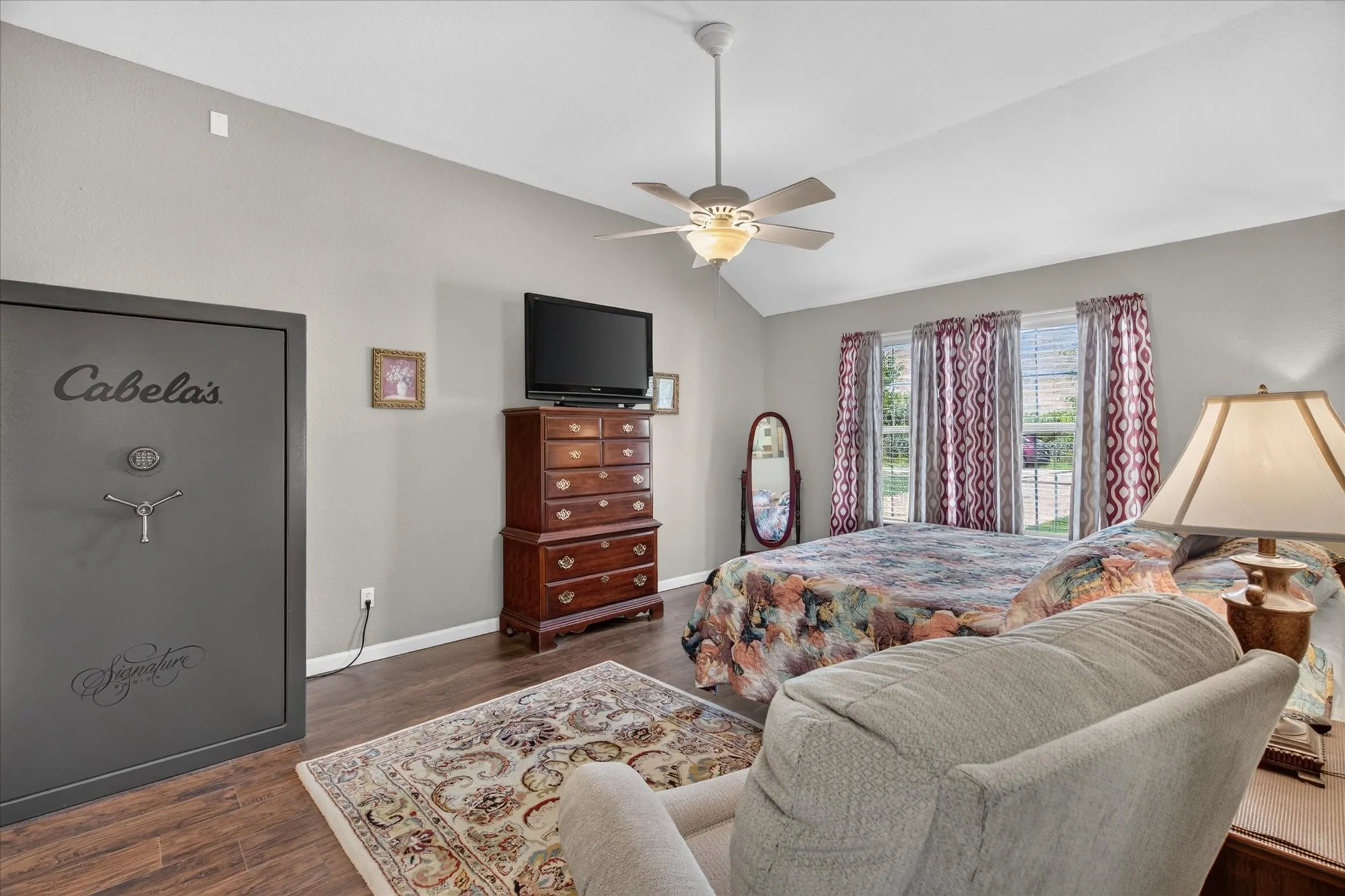 Vaulted ceilings, wood-finish flooring, and a ceiling fan with integrated lighting