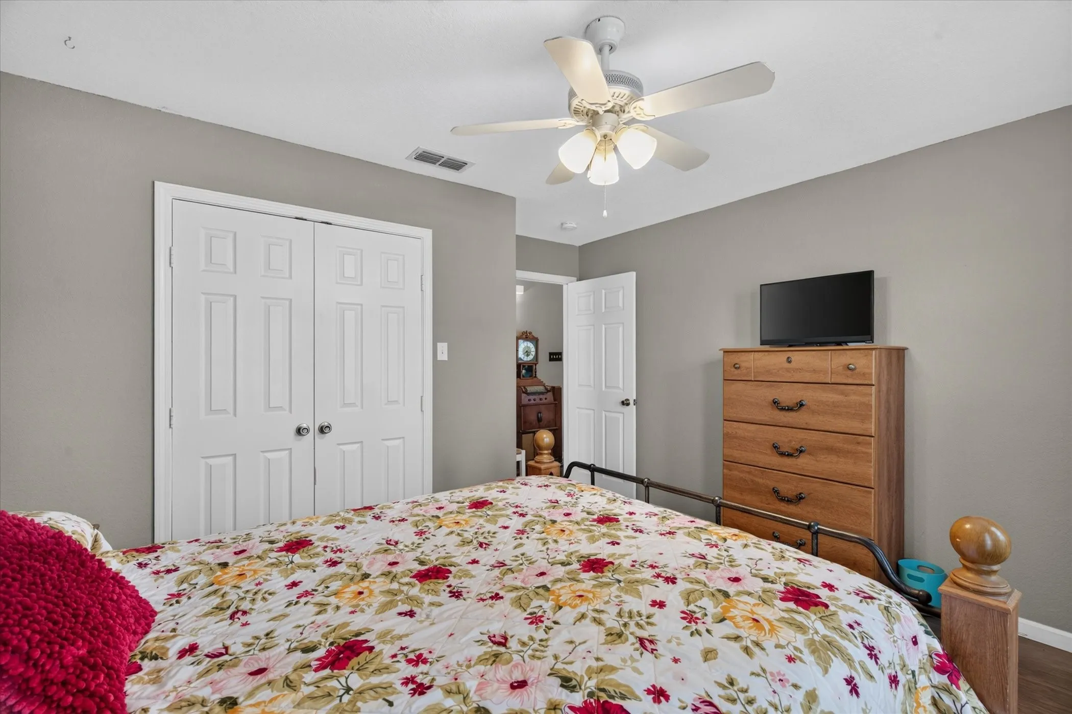 Room featuring neutral wall paint, white six-panel closet doors, and a ceiling fan with integrated lighting