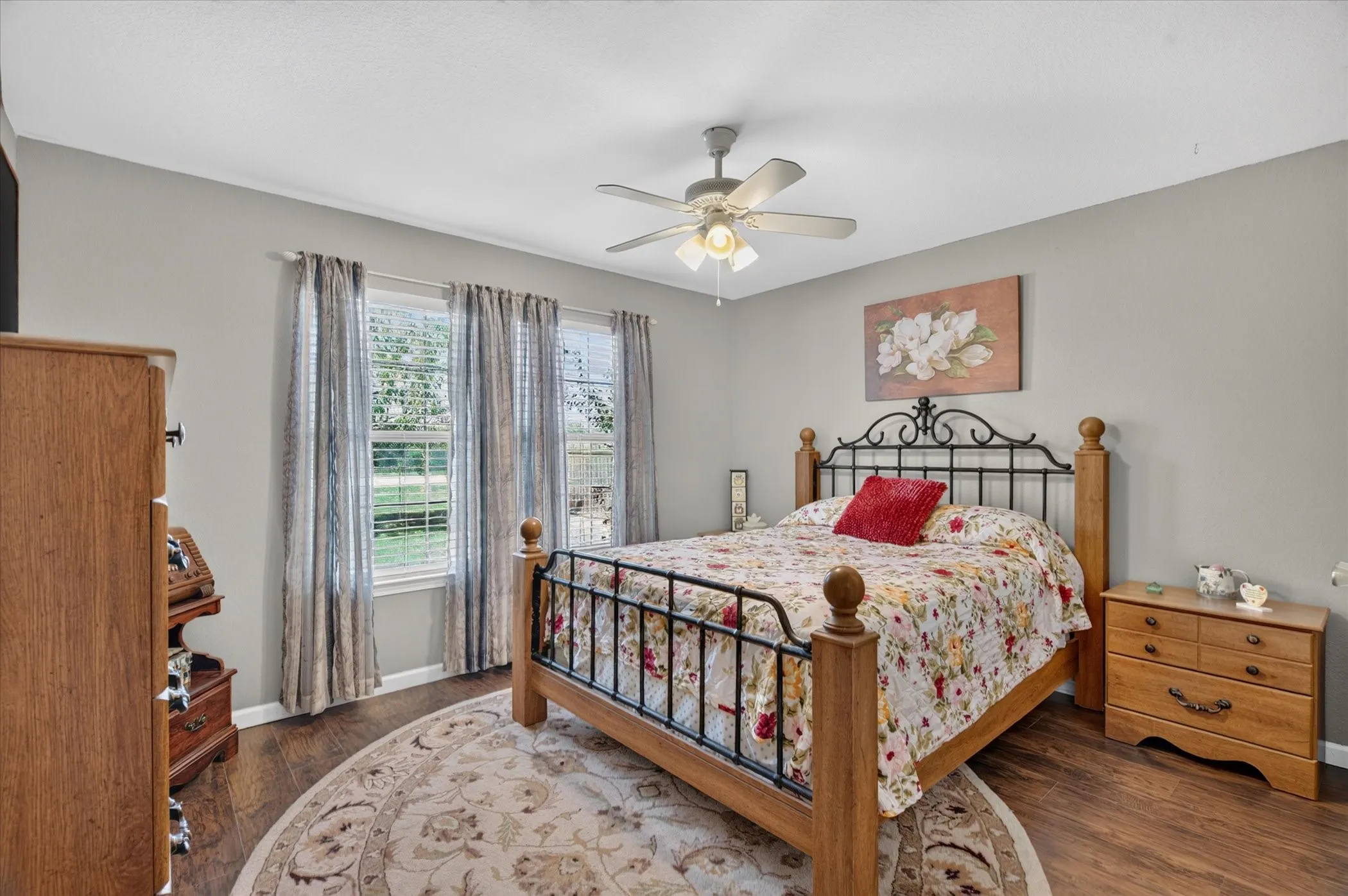 Room featuring wood-finish flooring, neutral wall color, and a ceiling-mounted fan with integrated light fixture