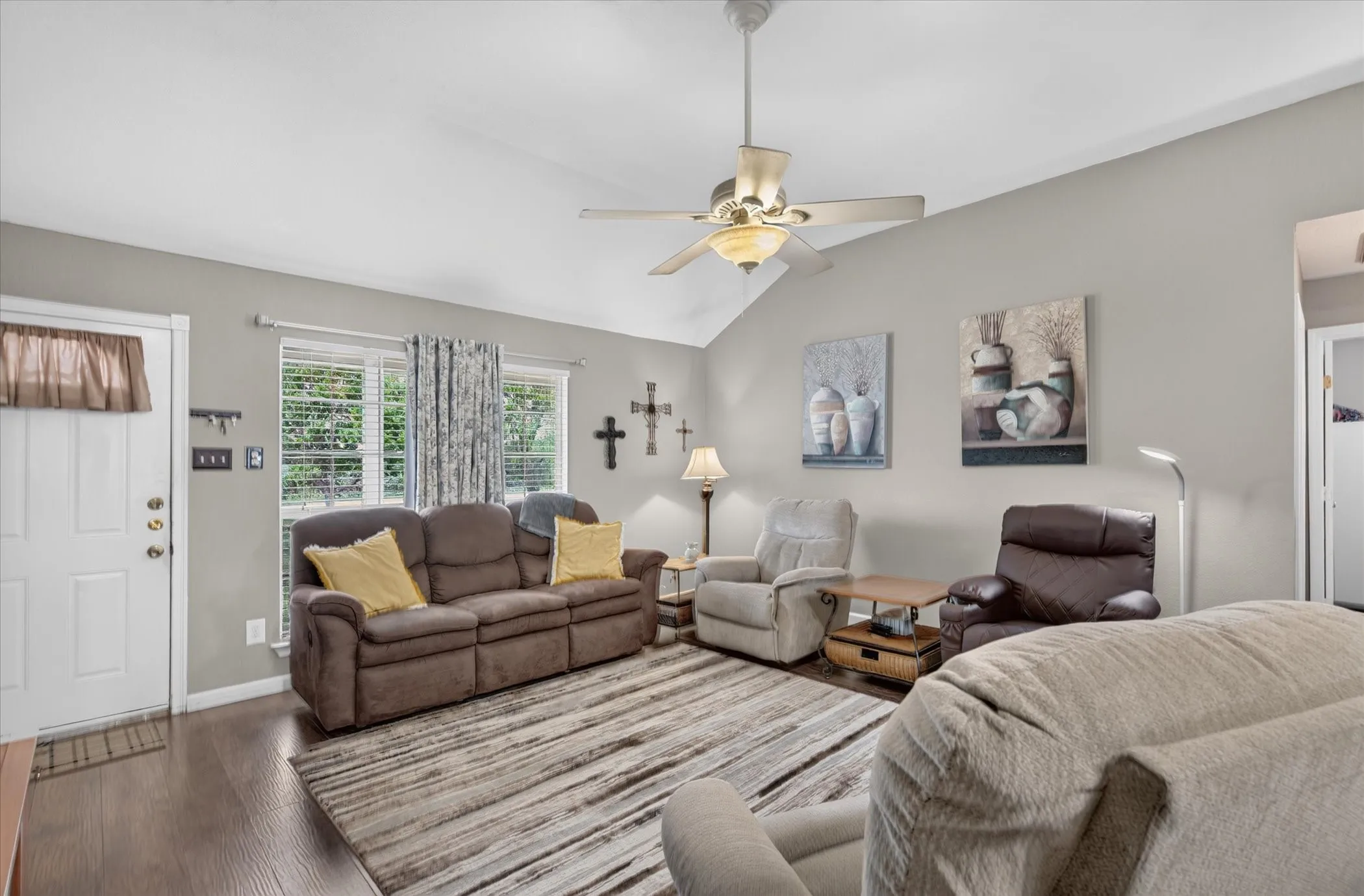 Vaulted ceiling, wood-finish flooring, and ceiling fan with integrated lighting
