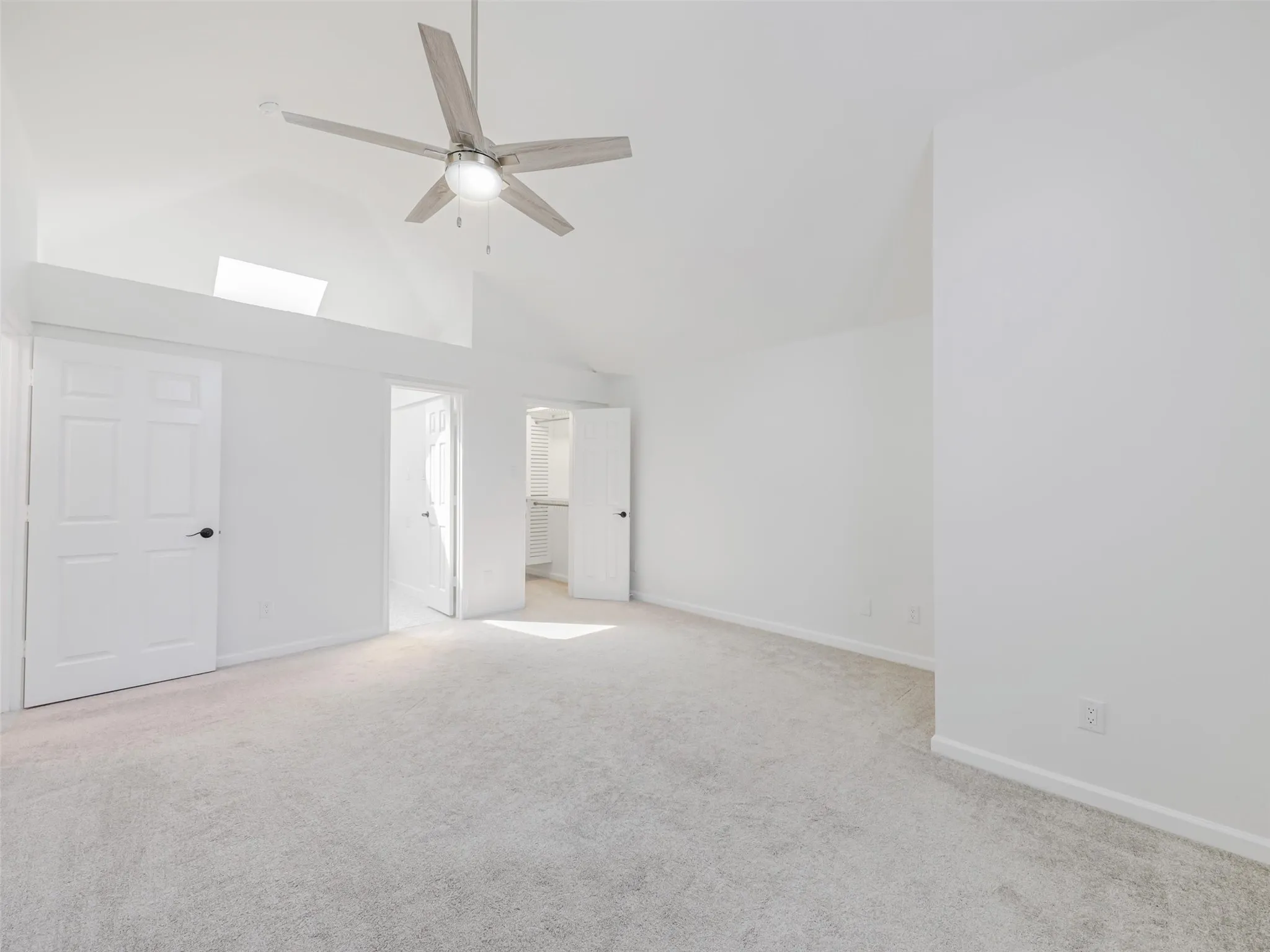 Vaulted ceilings featuring a skylight and a ceiling fan