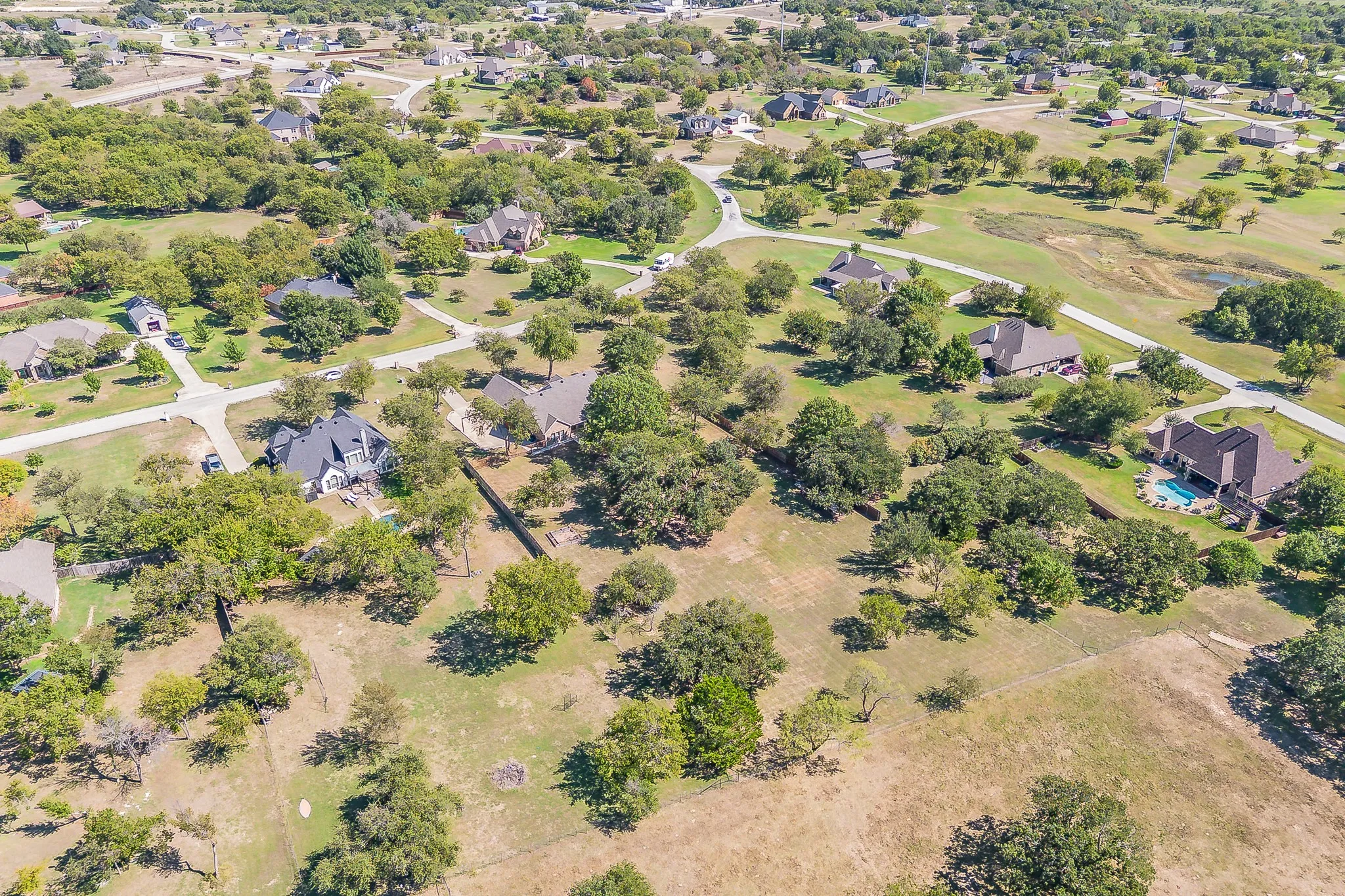 Expansive residential lot featuring mature oak trees scattered throughout the property, lush green landscaping, and generous acreage ideal for privacy and outdoor space