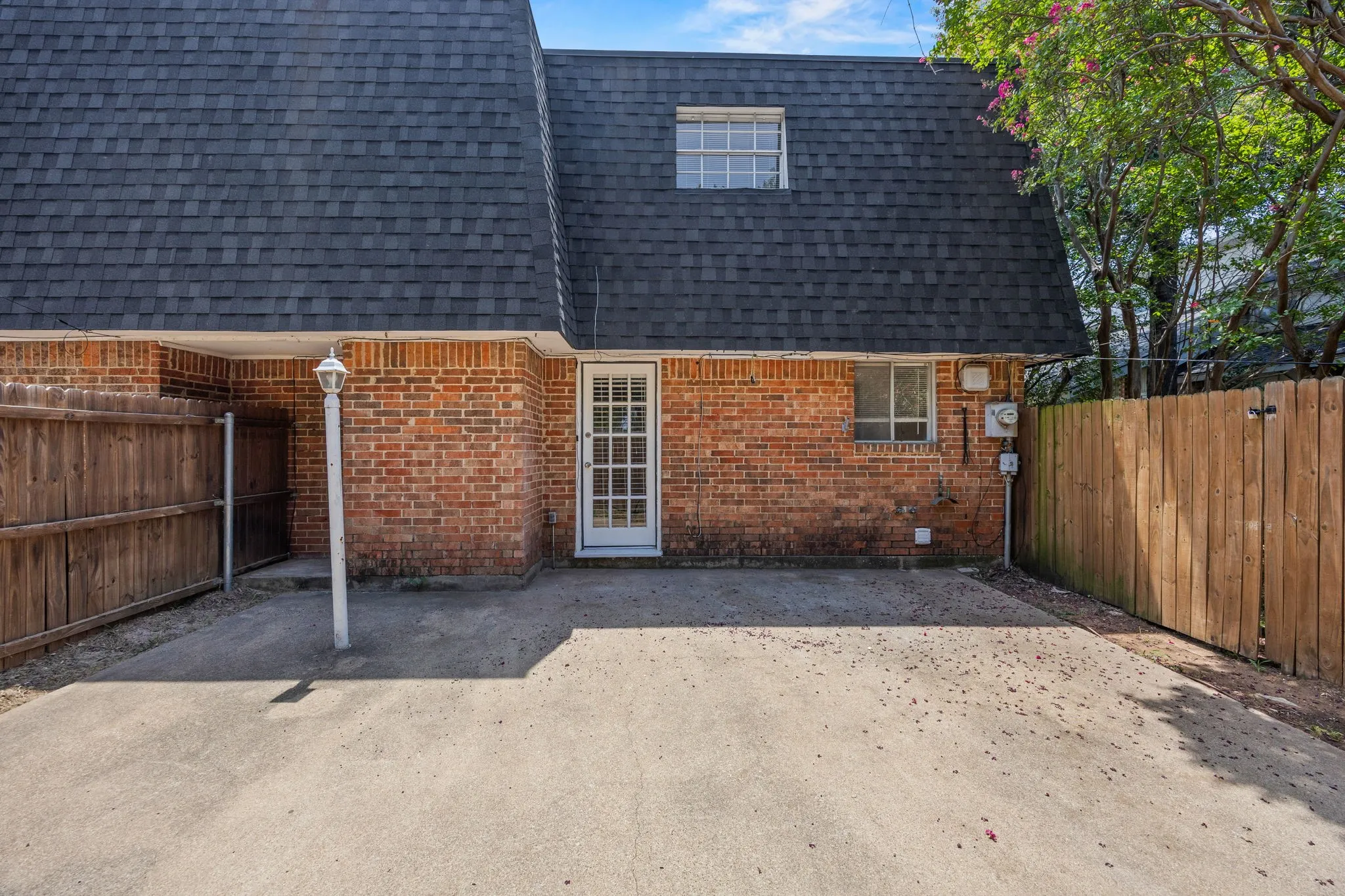 Brick exterior with a dark shingle roof and dormer window