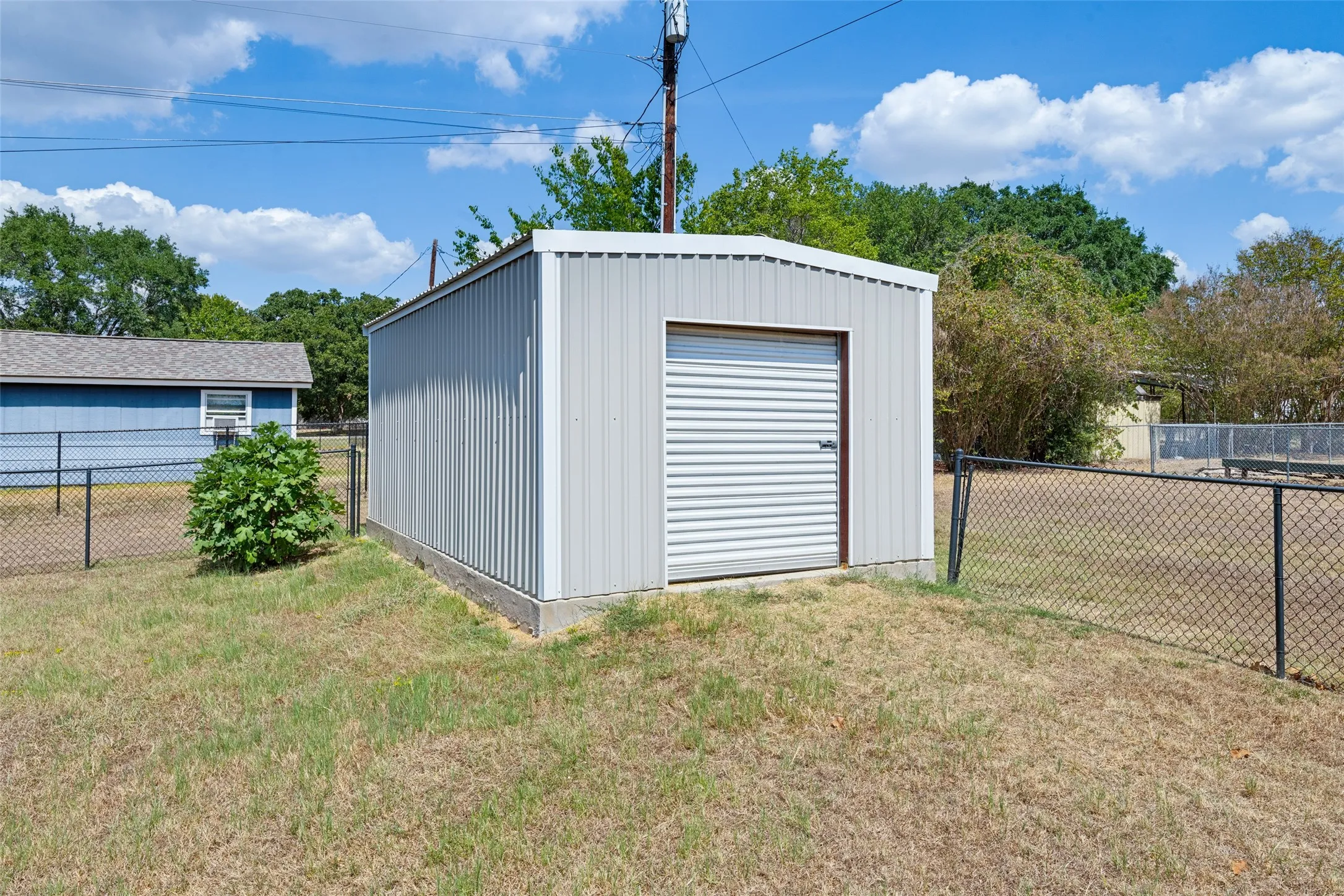 Metal storage shed featuring a roll-up door