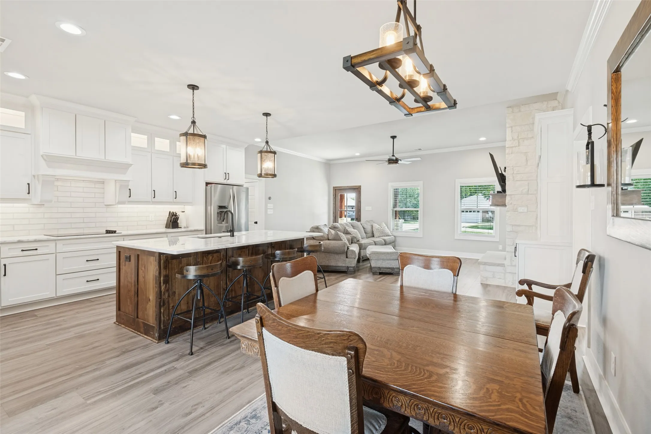 Kitchen featuring white cabinetry, subway tile backsplash, and a wood-finish island