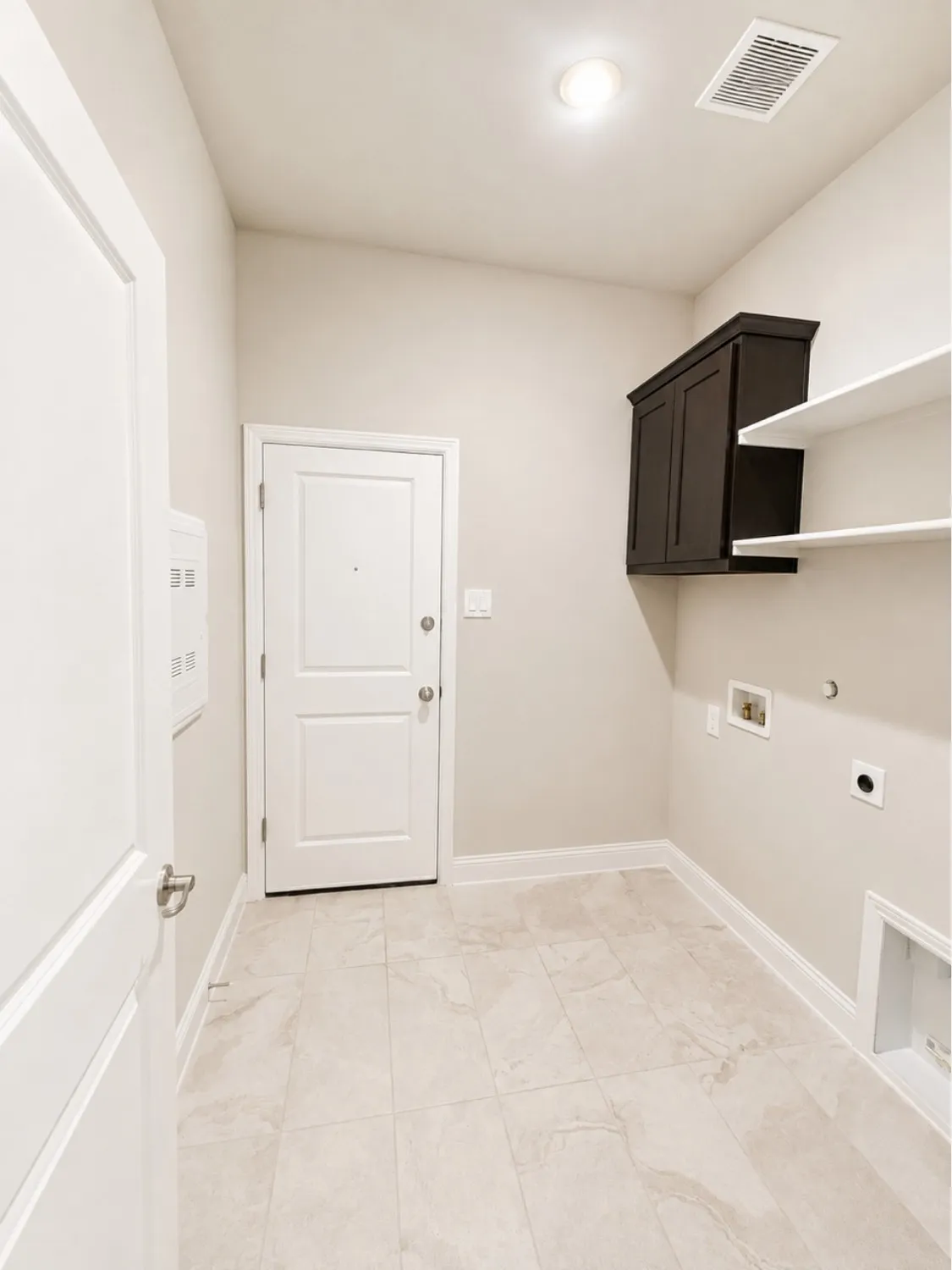 Utility space featuring light-toned tile flooring and painted walls