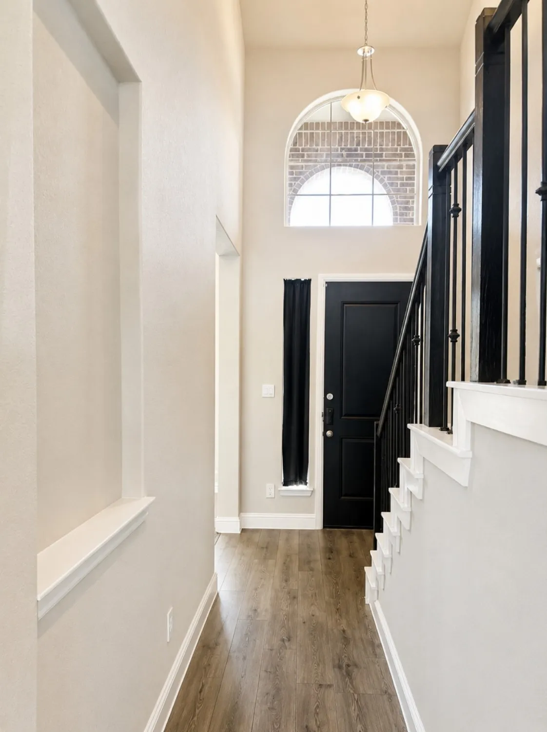 Grand entryway with high ceilings and wood-finish flooring